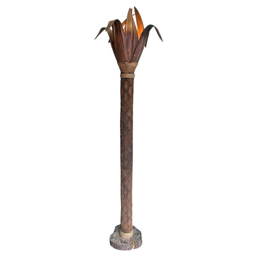 An unusual palm tree floor lamp with real palm trunk and wooden shaped leaves
