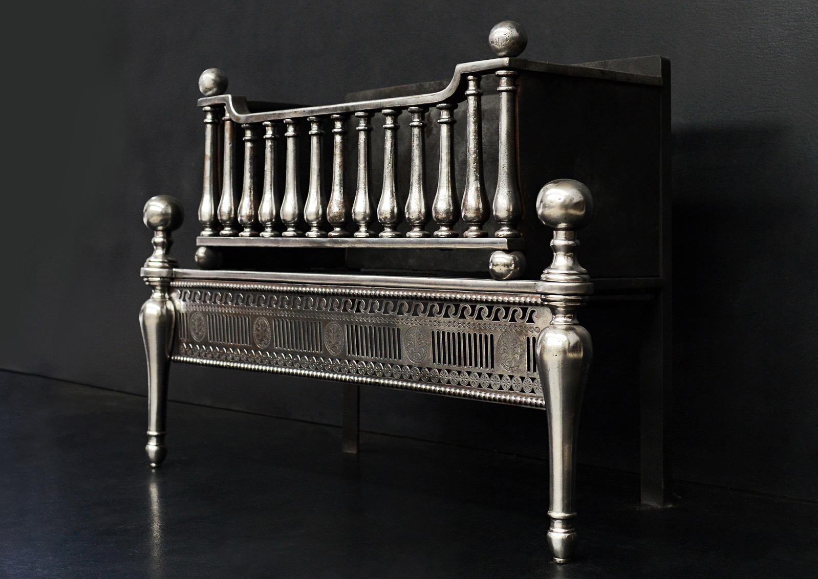 A good quality English polished steel firegrate. The engraved and fluted fret with beading above and below, the shaped legs surmounted by ball finials. The burning area with shaped upright bars surmounted by ball tops. 19th century.

Measures:
