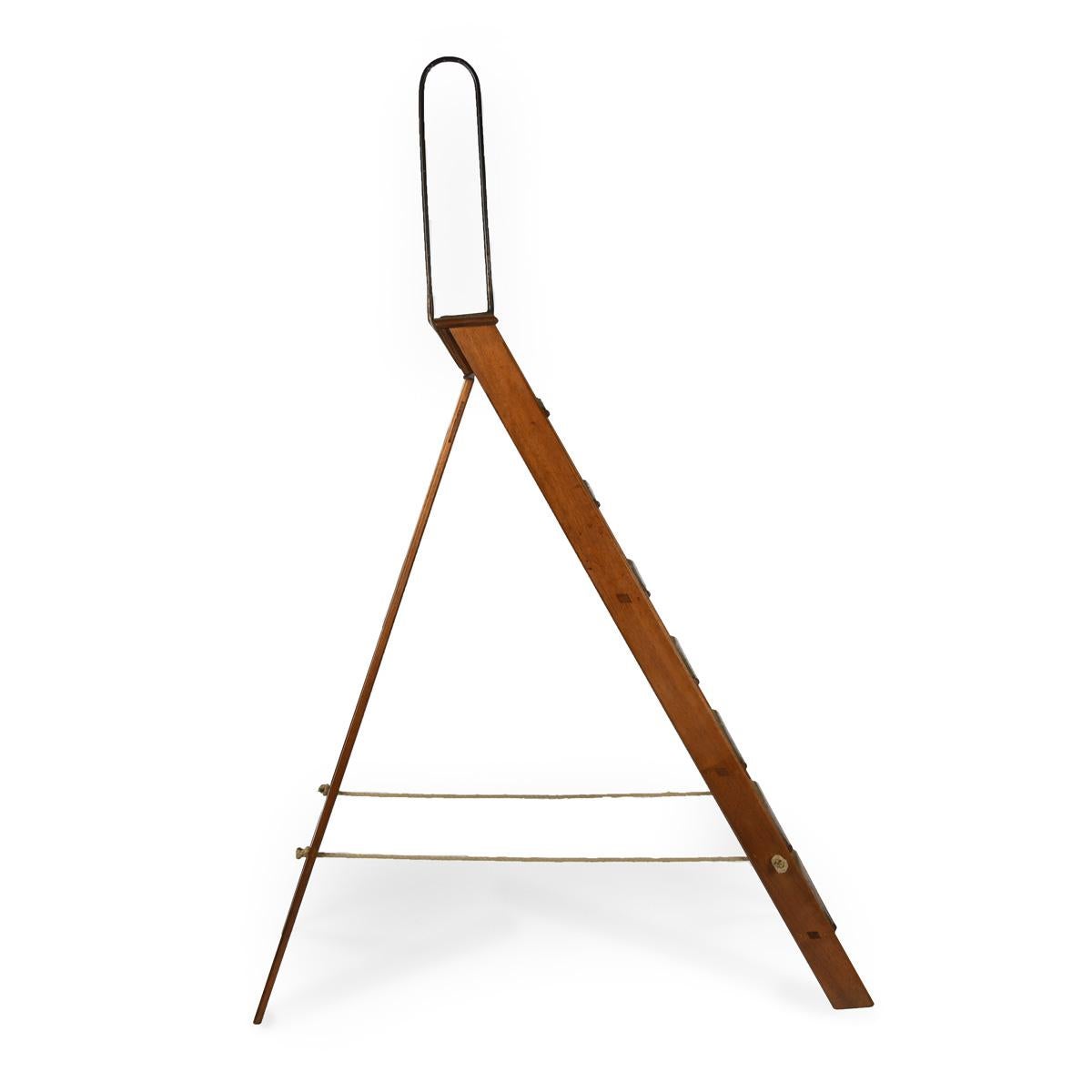 Un'insolita serie di gradini vittoriani pieghevoli in legno di noce, con il supporto originale in ferro e quello che sembra essere il battistrada originale in baize verde.

