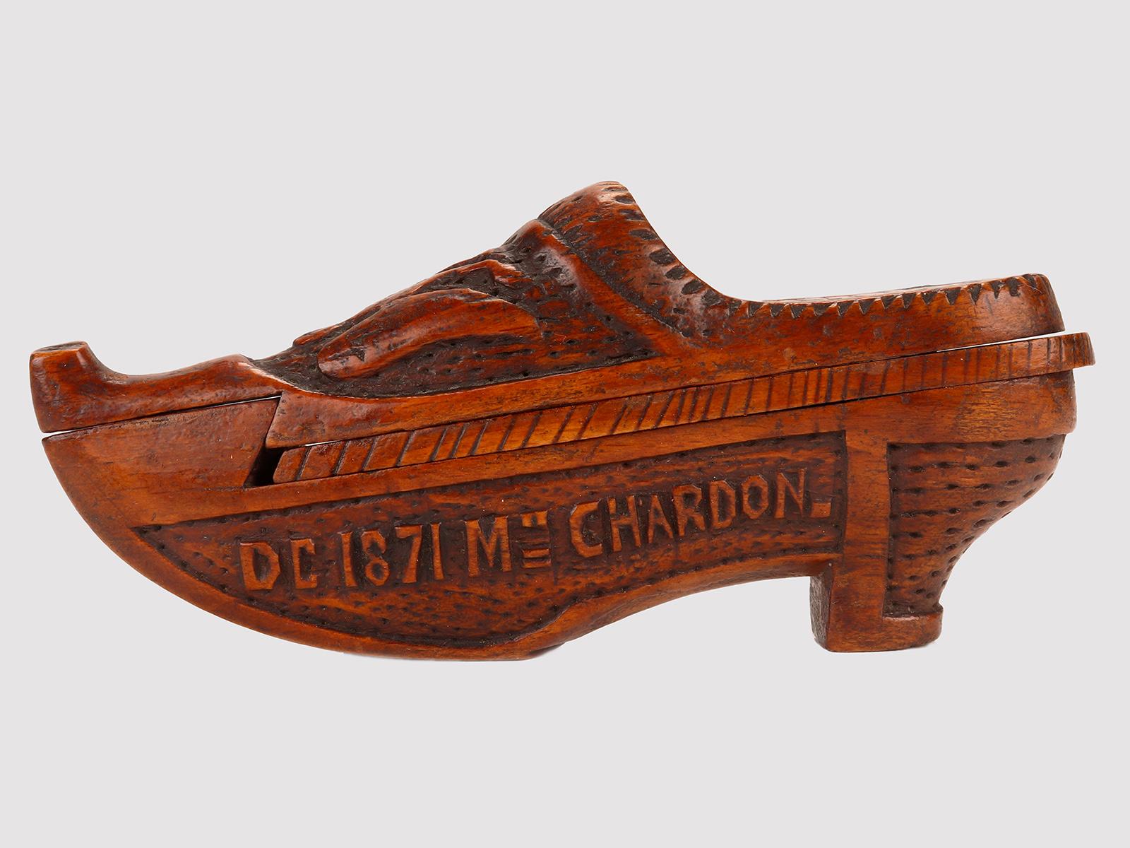 The snuffbox is in hazelnut wood carved in the shape of a shoe. The top opens to reveal a second part, with a lid that opens to reveal the tobacco container. On one external side, the dedication by D.C. is engraved. to Madame Chardon, in 1871, on
