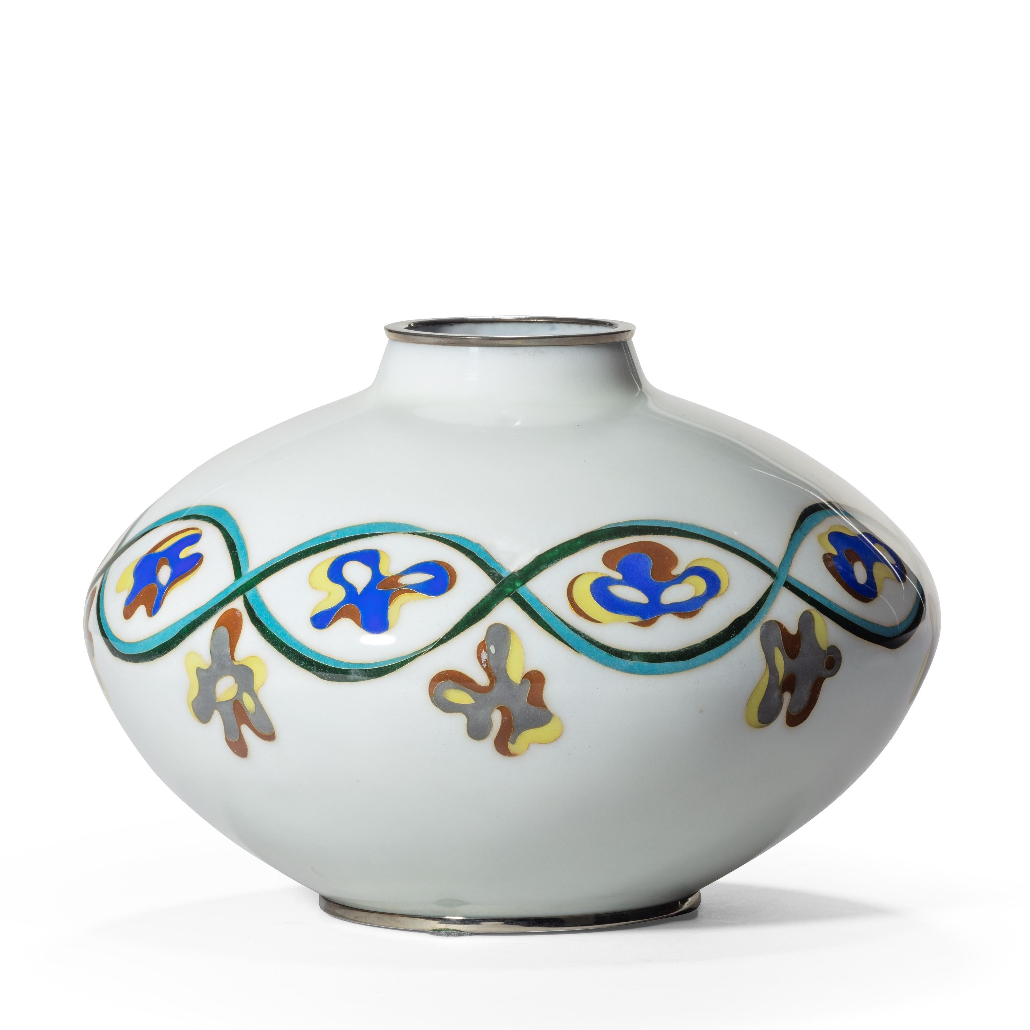 An unusual Showa period cloisonné vase, of squat ovoid form with continuous guilloche in turquoise and green enamels enclosing abstract designs in blue, yellow, brown and grey, with chrome mounts. Japanese, circa 1980.
  