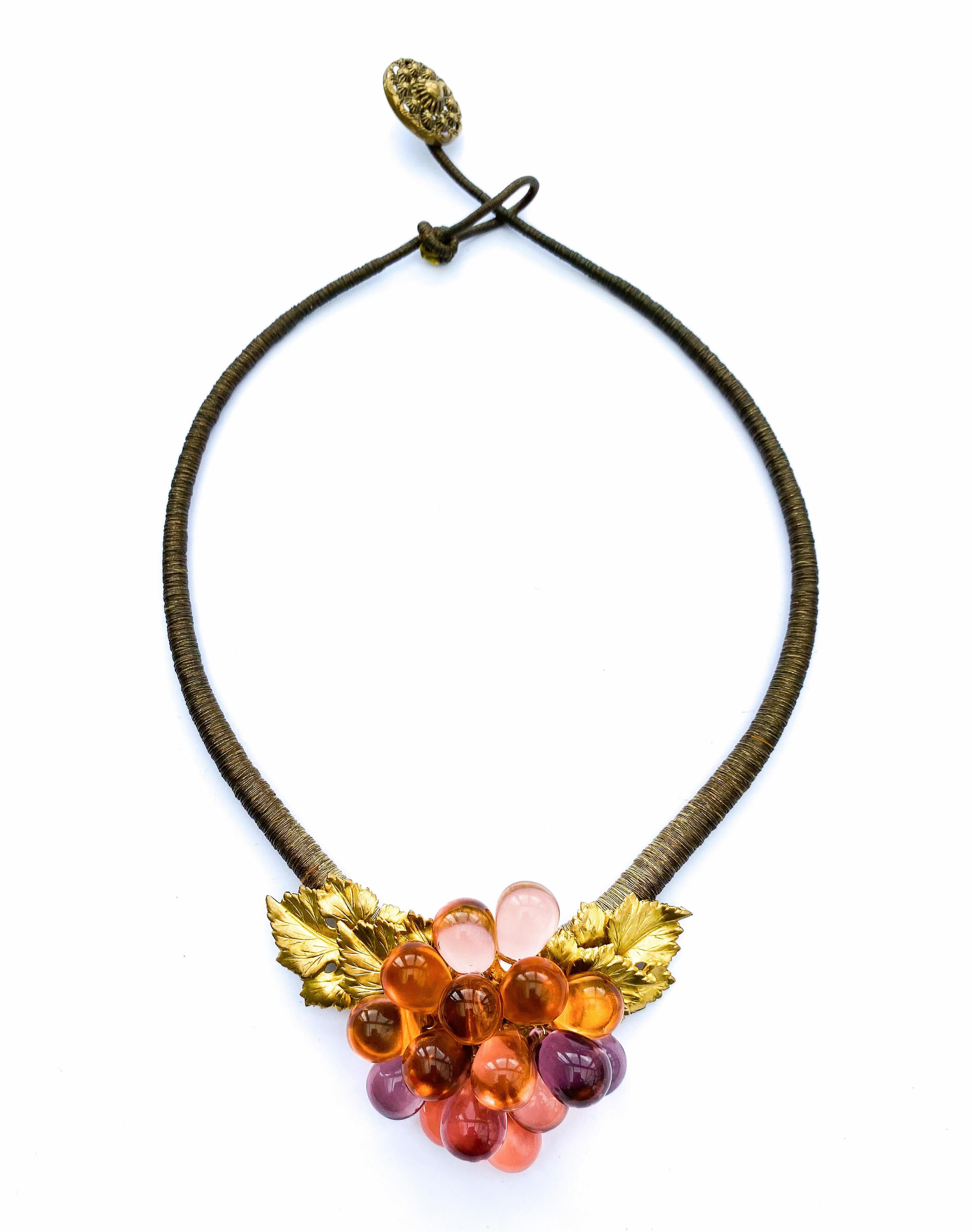 A highly unusual pendant necklace, from the 1920s, with a soft, subtle colour way, a gentle gilding mixed with transparent peach glass 'grapes', luminescent and eye catching - all mounted on a graduated necklace that is 'bound' in faded gilt bullion