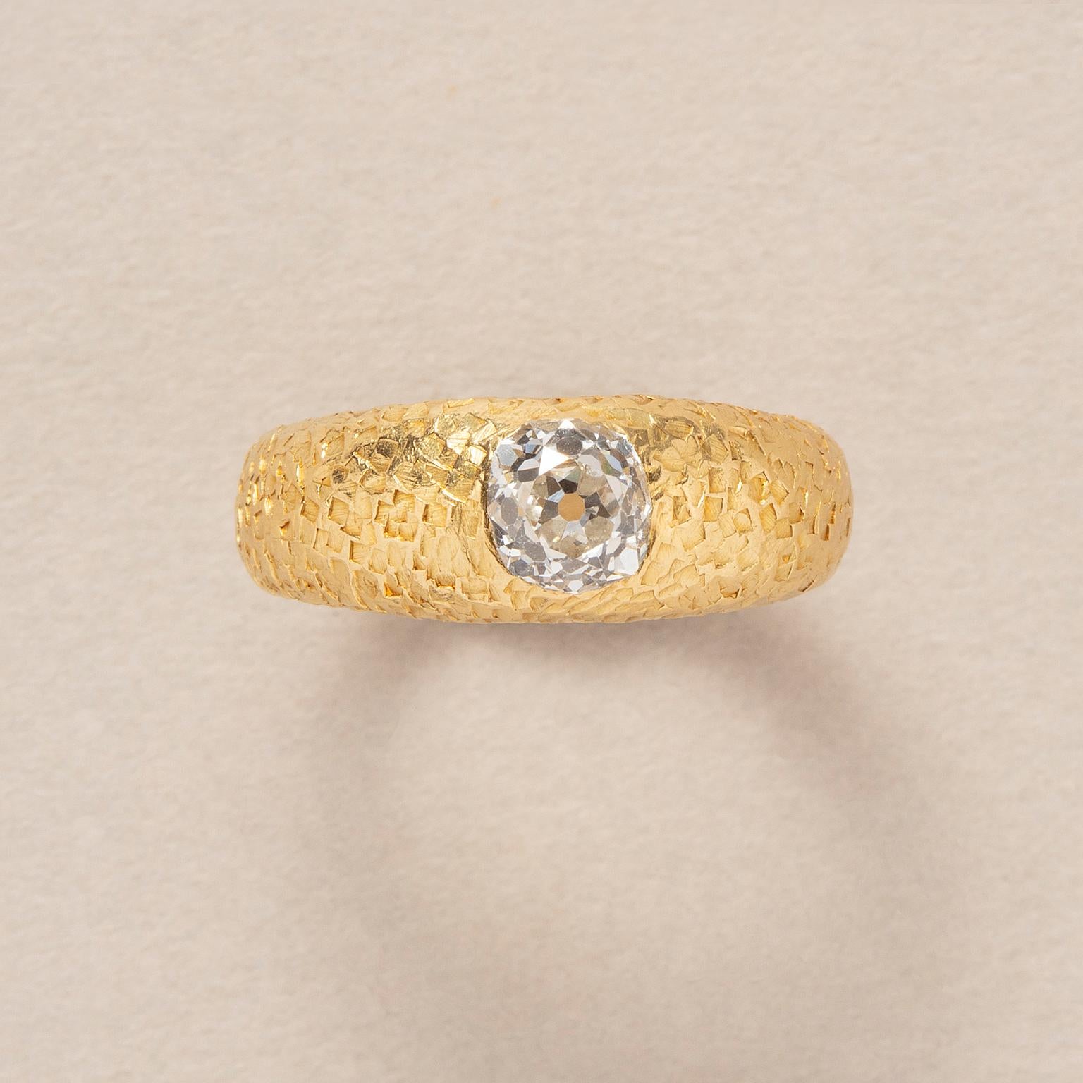 Solitärring aus 18 Karat Gelbgold, gehämmert, mit einem Diamanten im Altschliff (ca. 0,75 ct.). G-H VVs, 5,35 x 5,26 x 4,03 mm), bündig eingesetzt.

Gewicht: 7,44 g
Ringgröße: 17 mm / 7- US
Breite: 4 - 7,5 mm