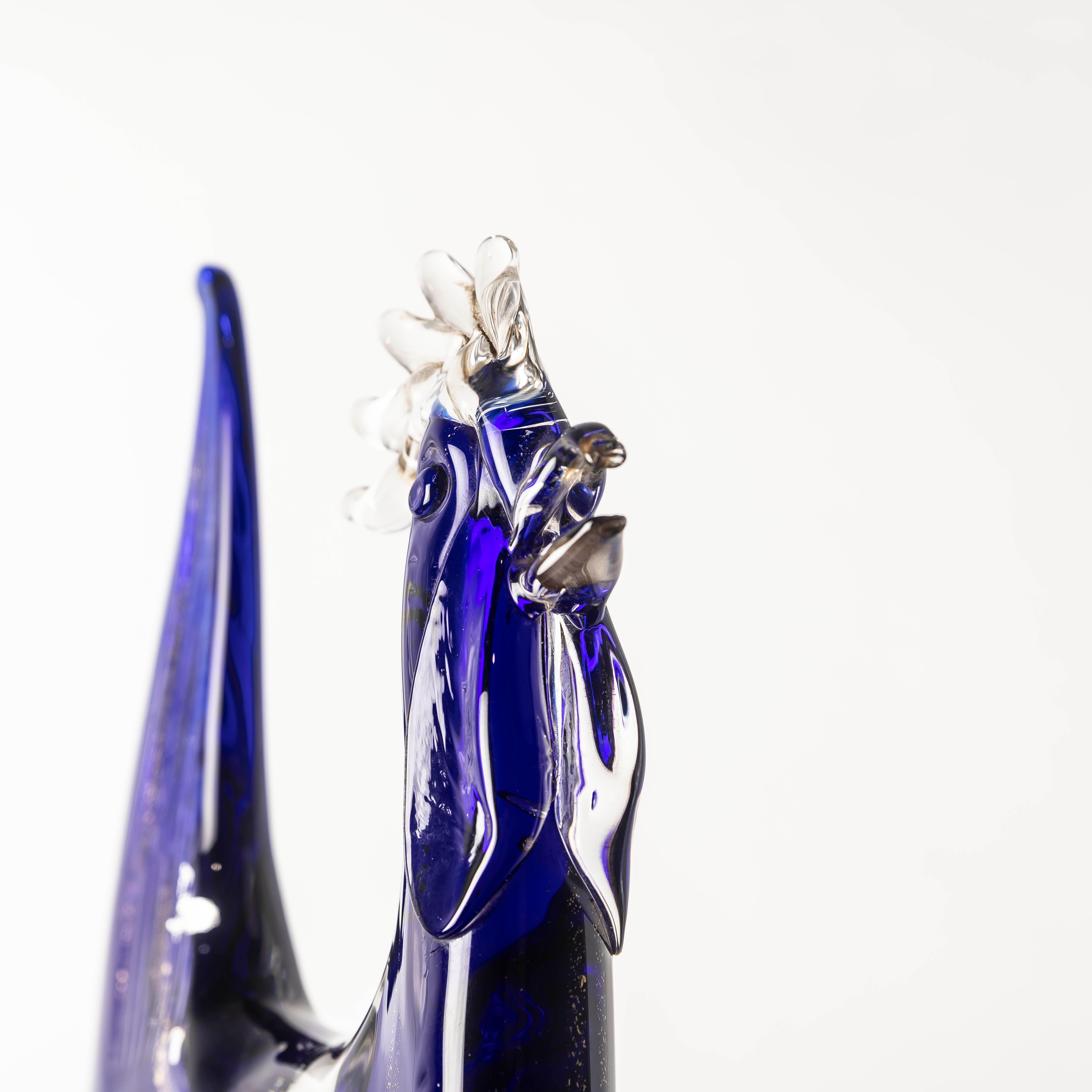 The XL Murano Blue Glass Rooster by Vicenzo Nason is an extraordinary piece of Italian glass artistry, blending bold design with exquisite craftsmanship. This striking sculpture, crafted on the legendary island of Murano, features gold and silver