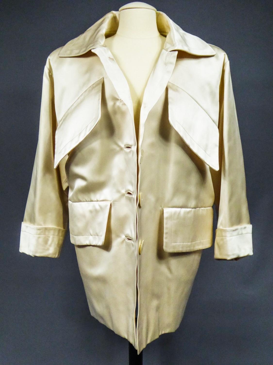 On hold for a french exhibition until November 2024, available after this date
Circa 1988/1990
France

Oversize Caban coat or navy-inspired sailor coat in cream silk satin by Yves Saint Laurent Haute Couture dating from the late 1980s. Provenance of
