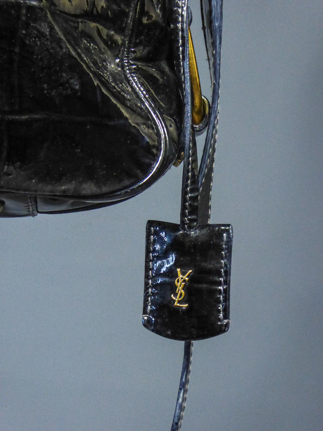 Ca. 1990/2000
Frankreich

Vintage-Handtasche aus schwarzem Lackleder, das eine zerkratzte Haut imitiert, von Yves Saint Laurent Rive Gauche aus den späten 2000er Jahren. Inspiriert von den 1940er Jahren und dem Geist der Sahara für diese Tasche mit