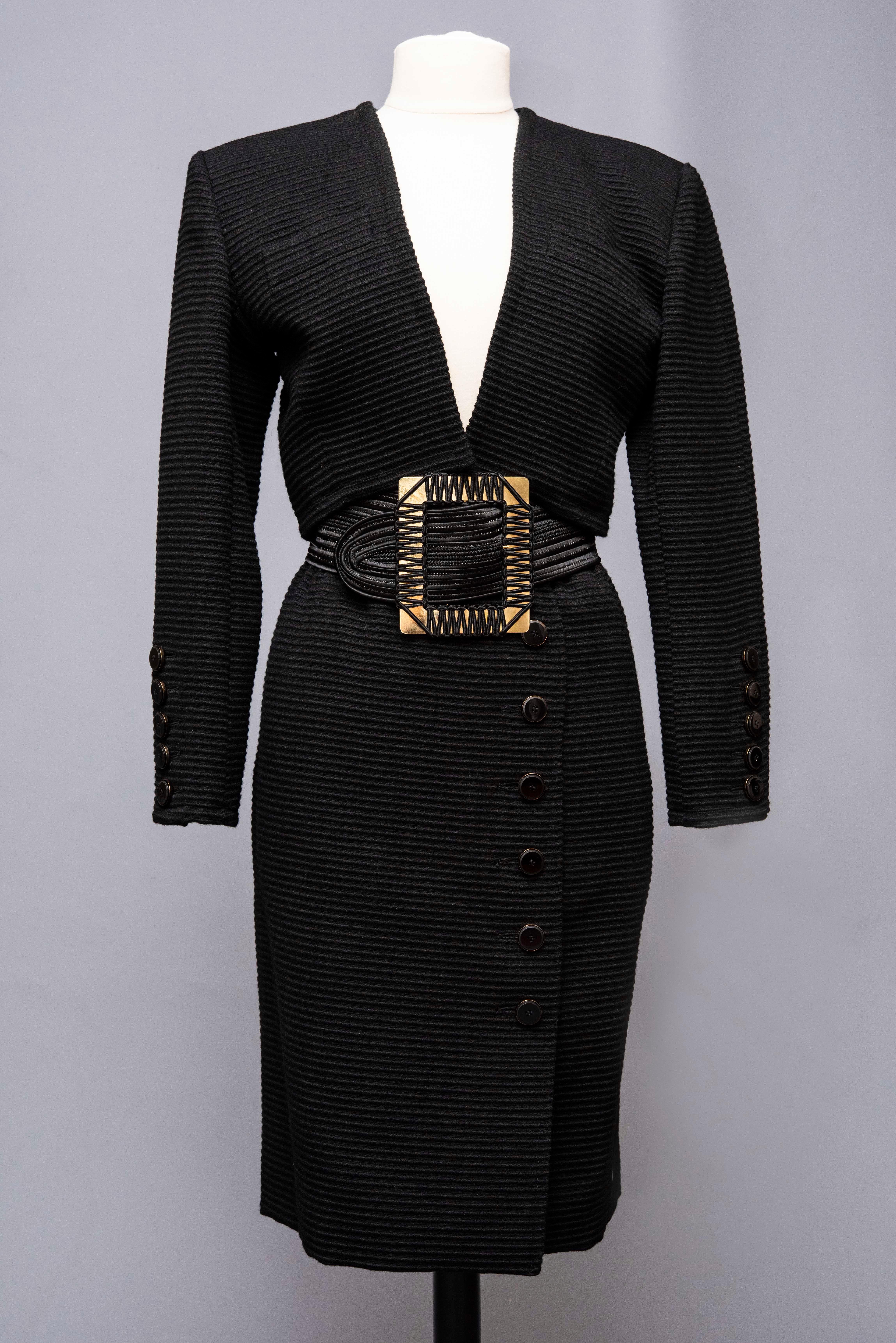 Circa 1988/1992

France

Iconic Yves Saint Laurent Rive Gauche skirt suit in wool fashioned with large parallel ribs Circa 1988/1992. High-waisted shoulder bolero with large polished jai buttons, gold-tone brass rims on the cuffs, with a recall on