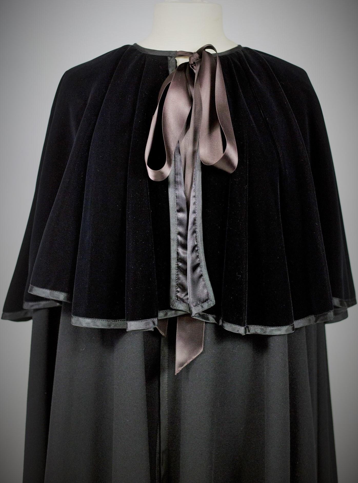 Circa 1980

France

Dramatic black cape for the evening by Yves Saint Laurent Rive Gauche dating from the 1980s. Important background in woolen Cashmere (?) sheet of 830 cm span ! Shoulders covered with a black silk velvet over-cape tied at the neck
