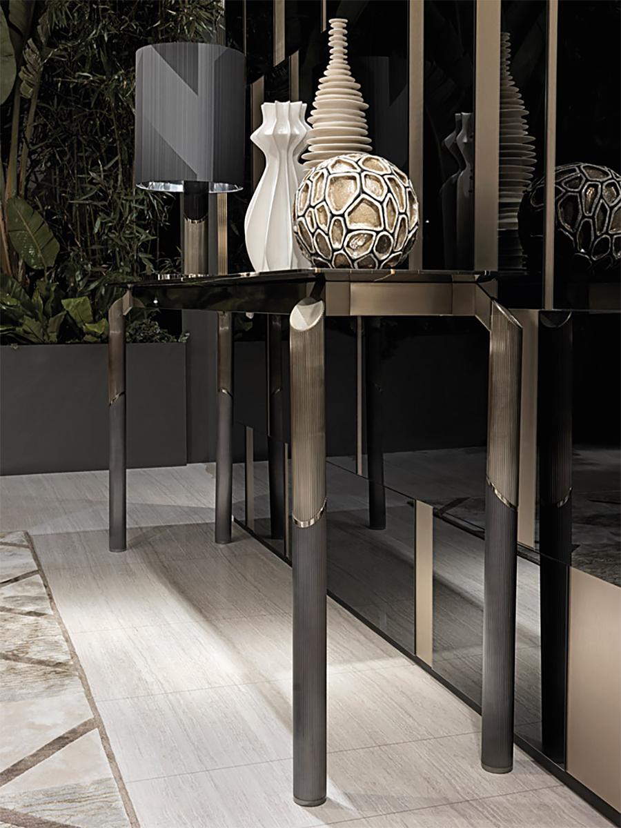 Console Table Anabet with base structure in steel and 
solid brass. With 4 cylindric legs in satinized finish and
console table with black sahara polished marble top in
glossy finish.