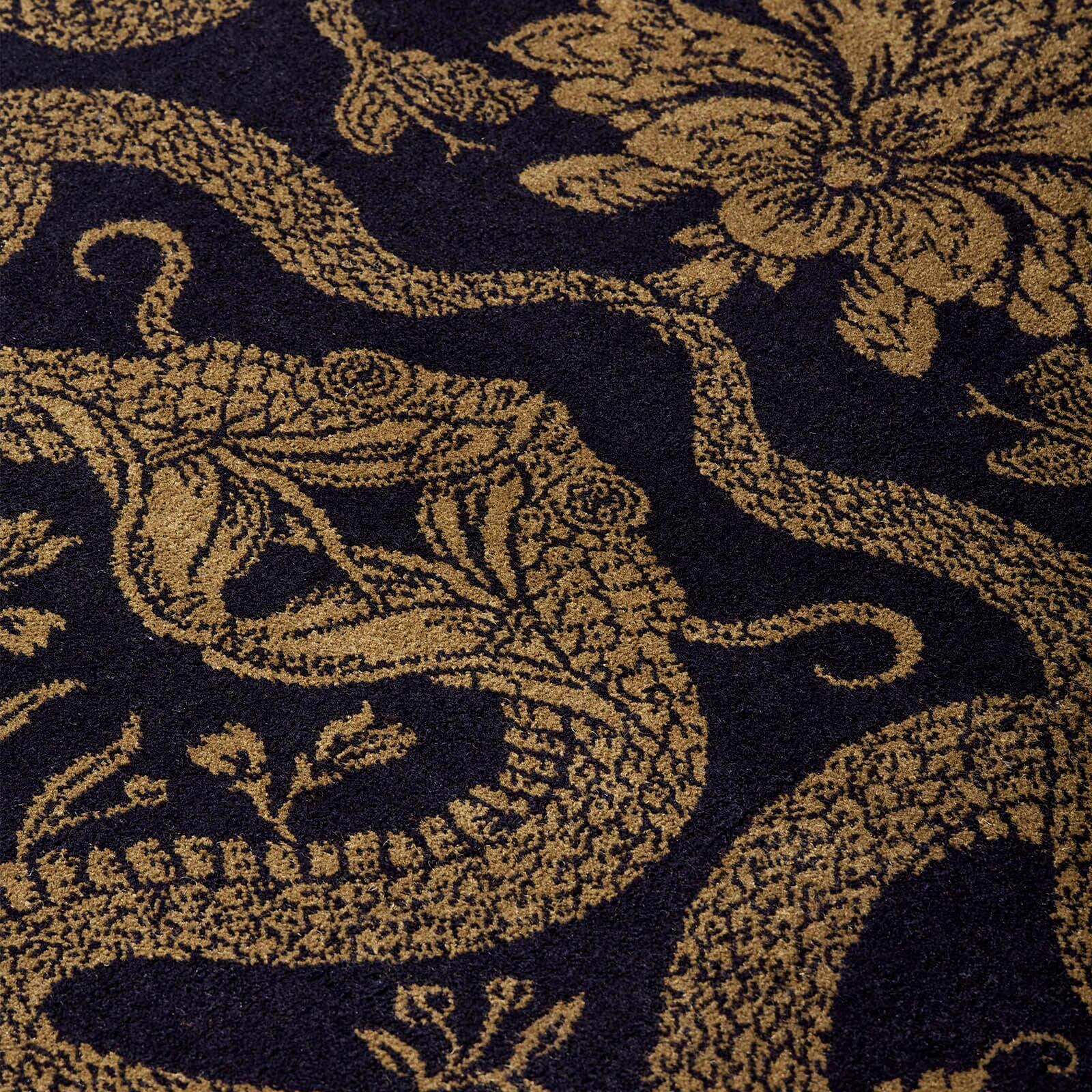 Fear not the snakes slithering across the floor of your home for these are our House symbols of transformation and renewal. In a dramaticly opulent palette of black and gold the subversively beautiful ANACONDA rug is woven by Axminster Carpets the