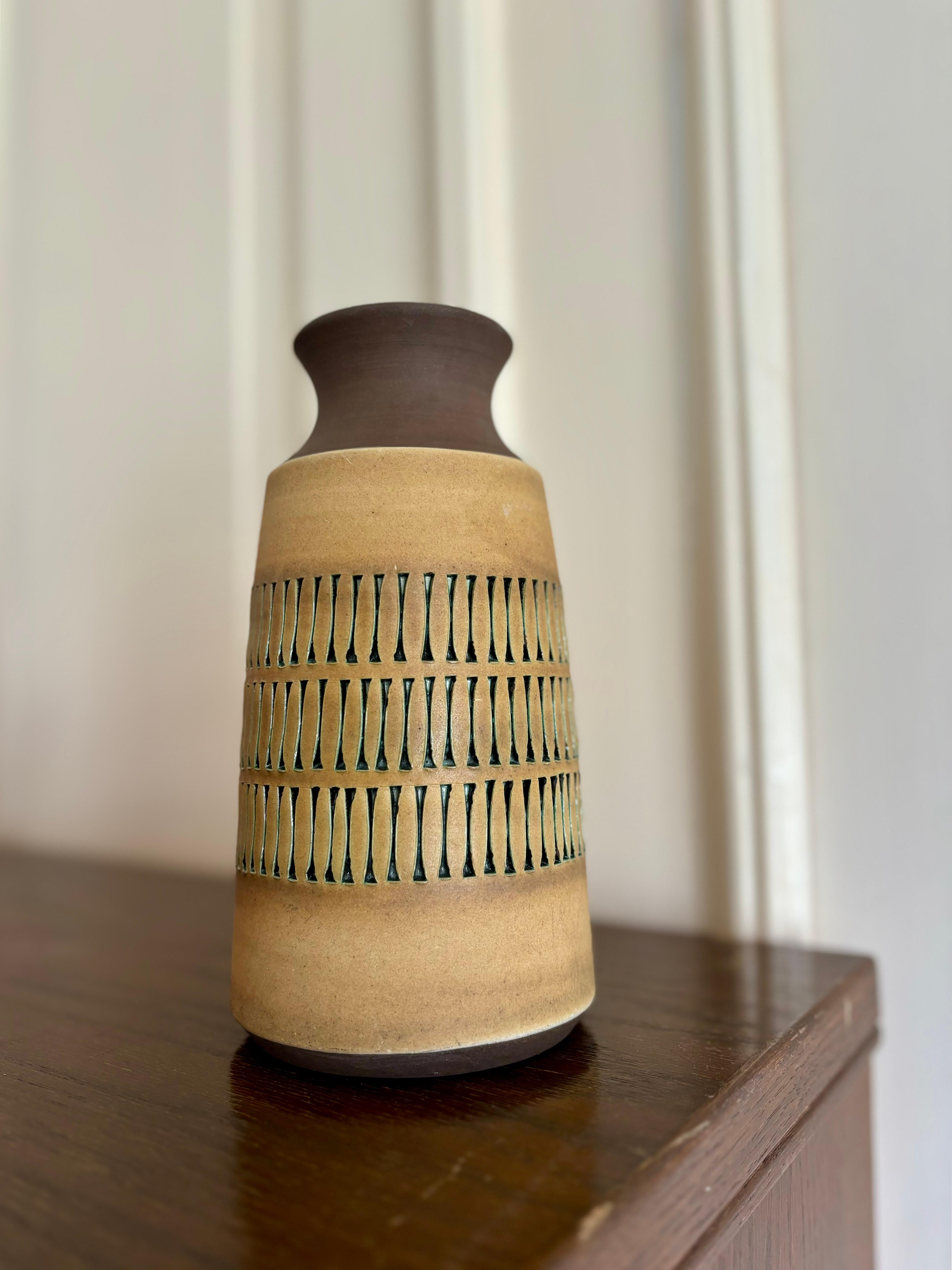 Vaso in ceramica vintage della metà del secolo scorso dell'artista svedese Tomas Anagrius (1939-). Decorazione grafica in rilievo intagliata a mano con smalto verde scuro lucido in ogni linea intorno al ventre smaltato opaco marrone ocra chiaro.