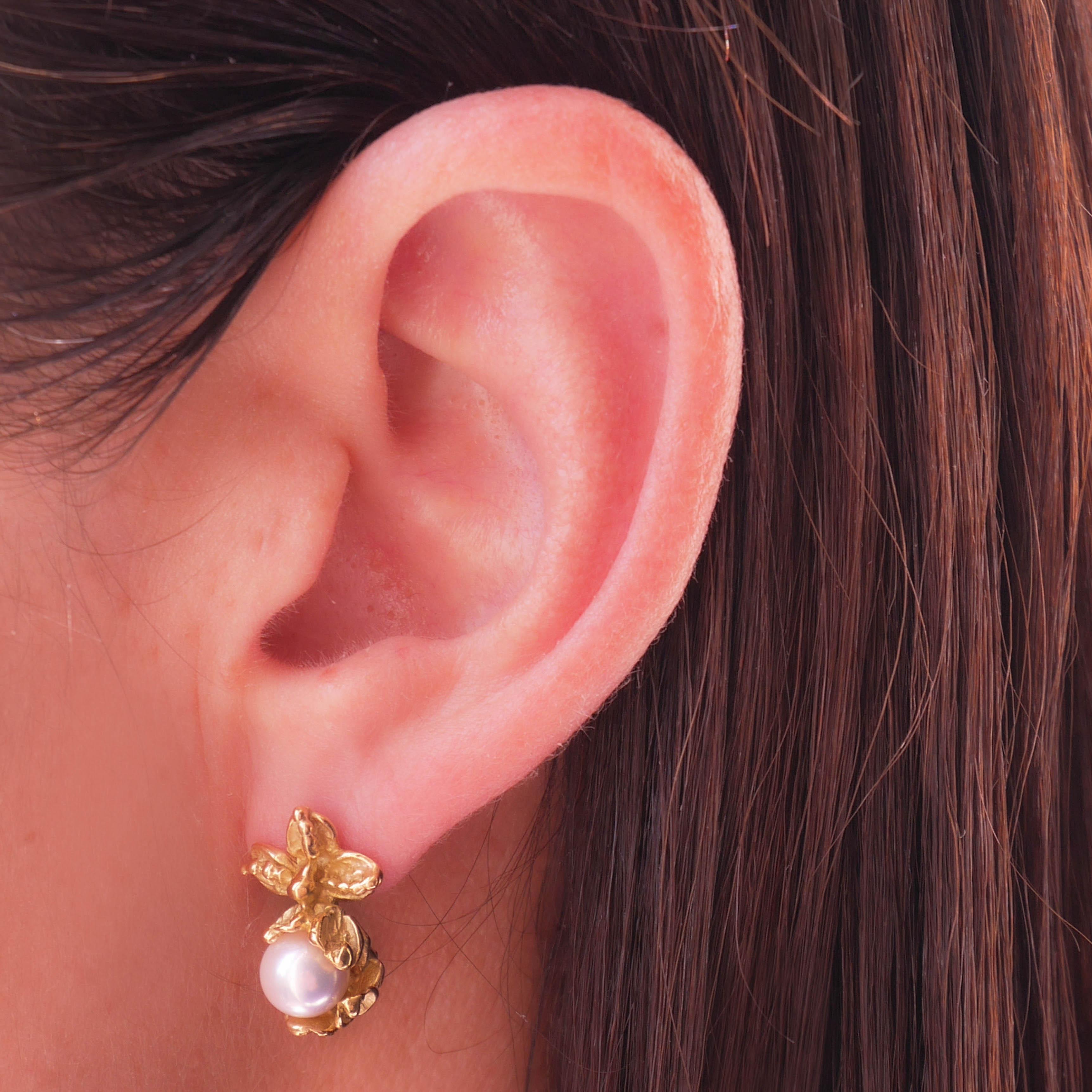 Handcrafted earrings in 18 karat yellow gold weigh app. 3grm. The earrings are each set with a lustrous Akoya pearl, each leaf has been hand-engraved by using time-honored techniques. 
Bell-back Alpa fastening for pierced ears.
The craftsmanship is