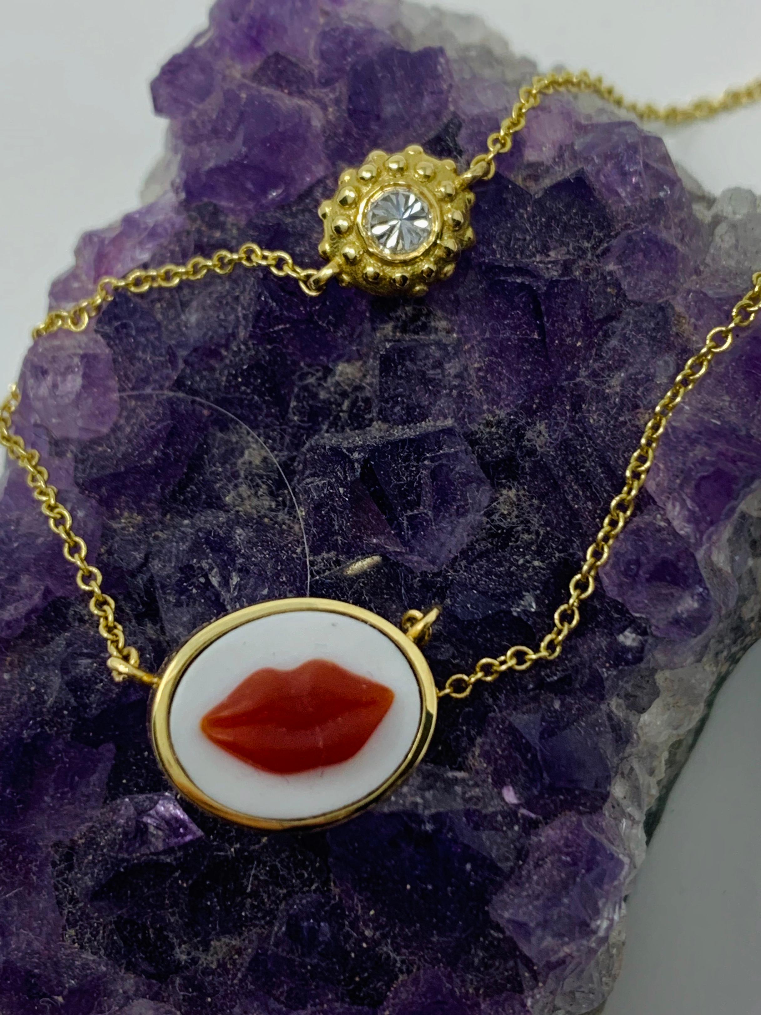 'Lady is a Tramp' cameo charm bracelet is a work of art! The cameo is hand carved in Brazilian red agate and encircled in 18k rose gold.  A sea urchin is set with an inverted diamond that sits in the chain to the right of the lip cameo. The ajure