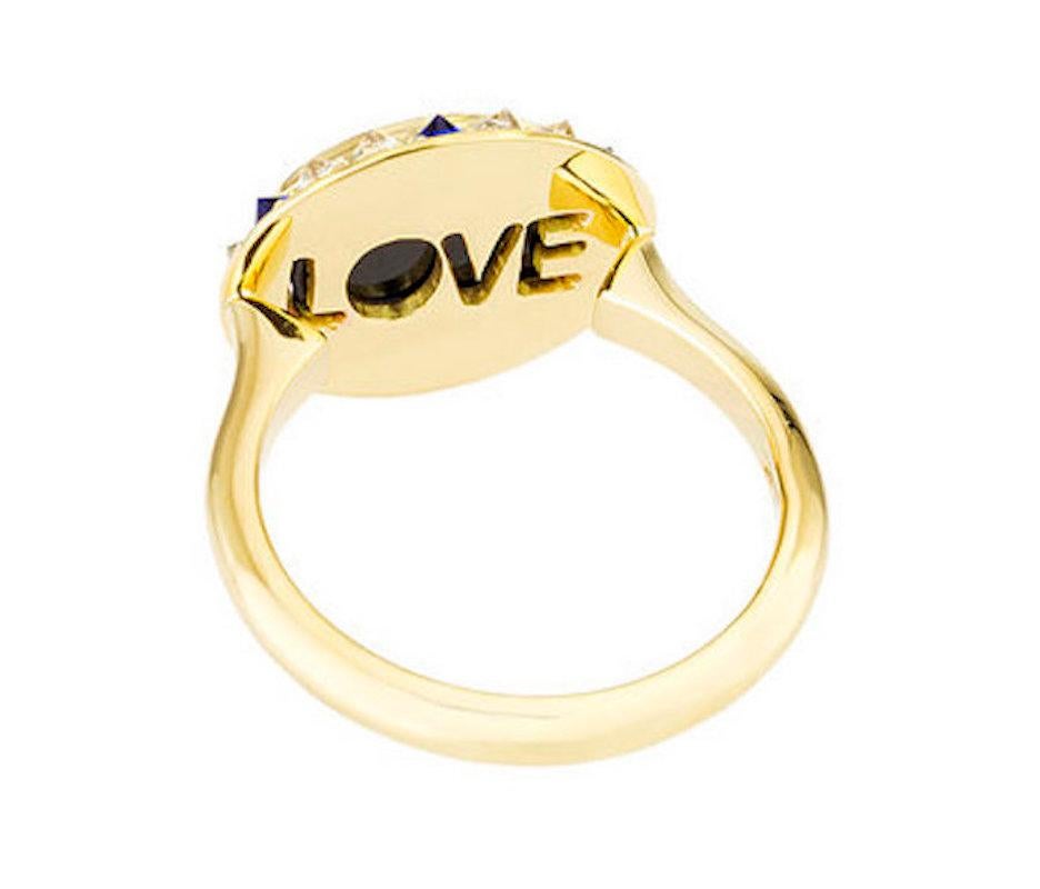 The blue agate cameo is hand-carved by a master carver bringing out the colors and depth within the stone's layers. The cameo is encased in yellow gold, inverted diamonds, and sapphires. As in every piece of the Eye Love collection, ‘love’ is carved