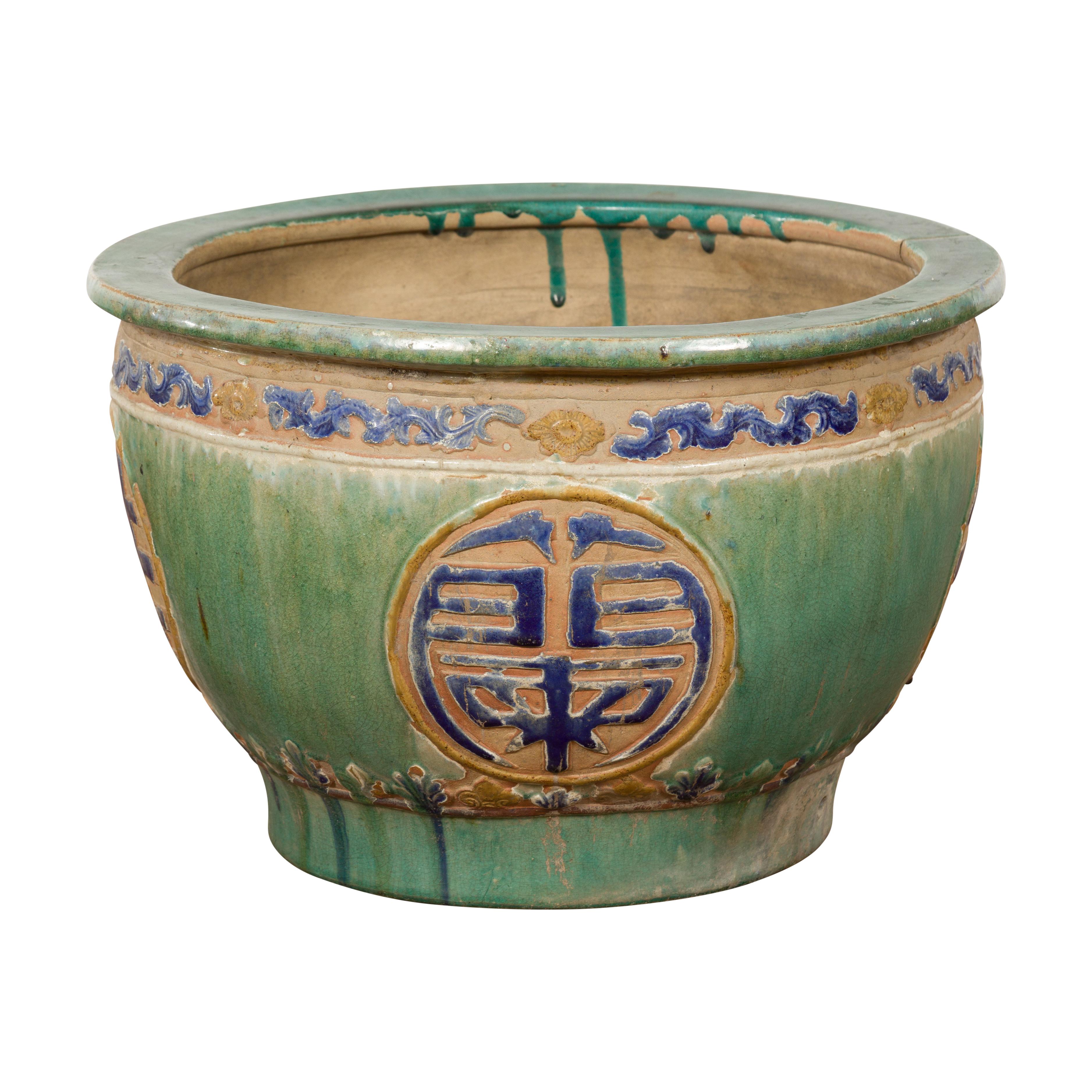 An antique 19th century Annamese green and blue planter from Vietnam with calligraphy in medallions, scrolling clouds frieze and distressed patina. Uncover the timeless beauty of this antique 19th century Annamese planter from Vietnam. Crafted with