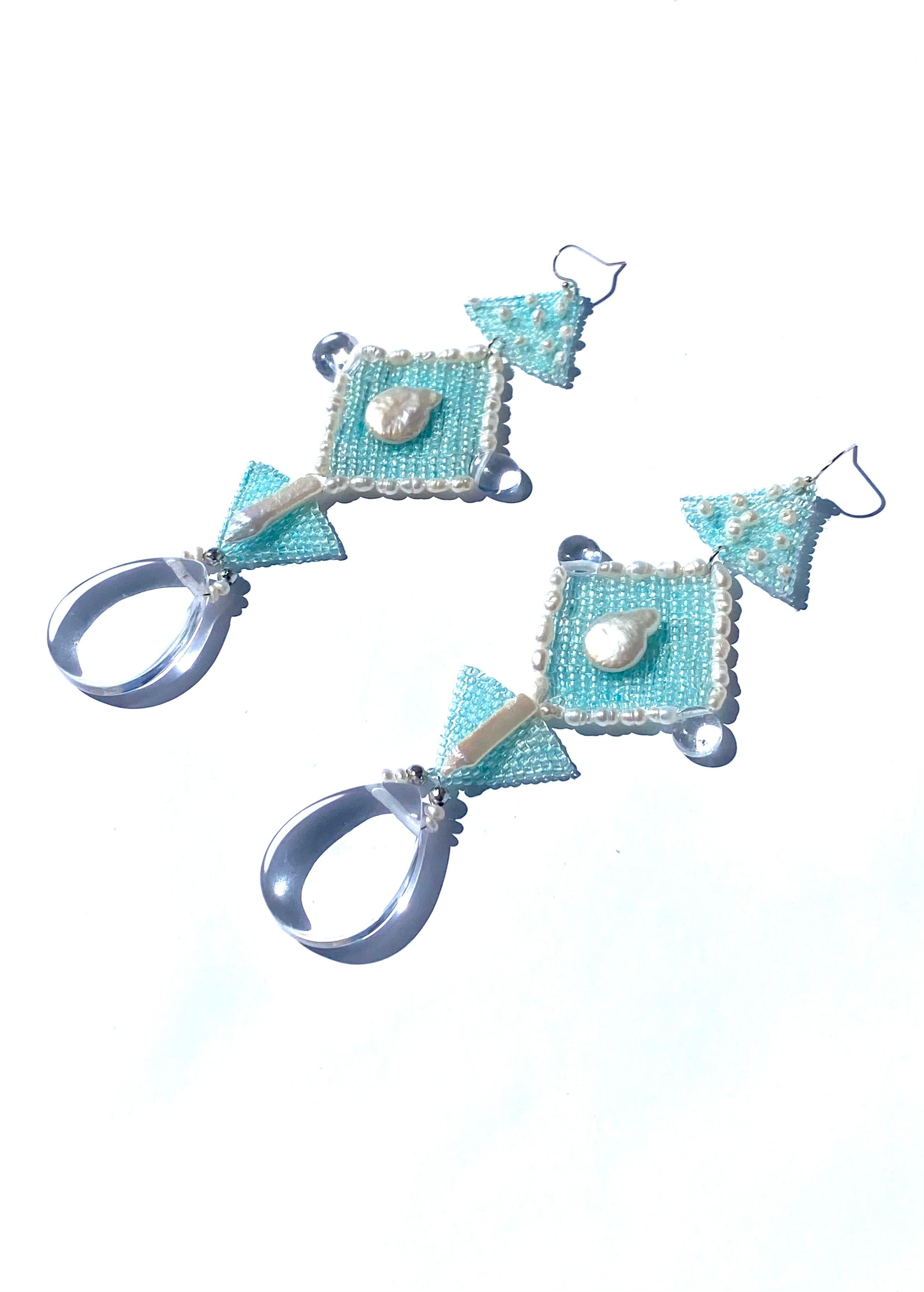 Handwoven glow in the dark sea foam blue glass Japanese seed beads embroidered with freshwater pearls and quartz. At the tip of the earring a large pear shaped quartz crystal stone dangles, symbolizing the sanctity and strength of water. According