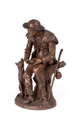 Scultura in bronzo di Anatole J. Guillot raffigurante "Scultore seduto con cane".