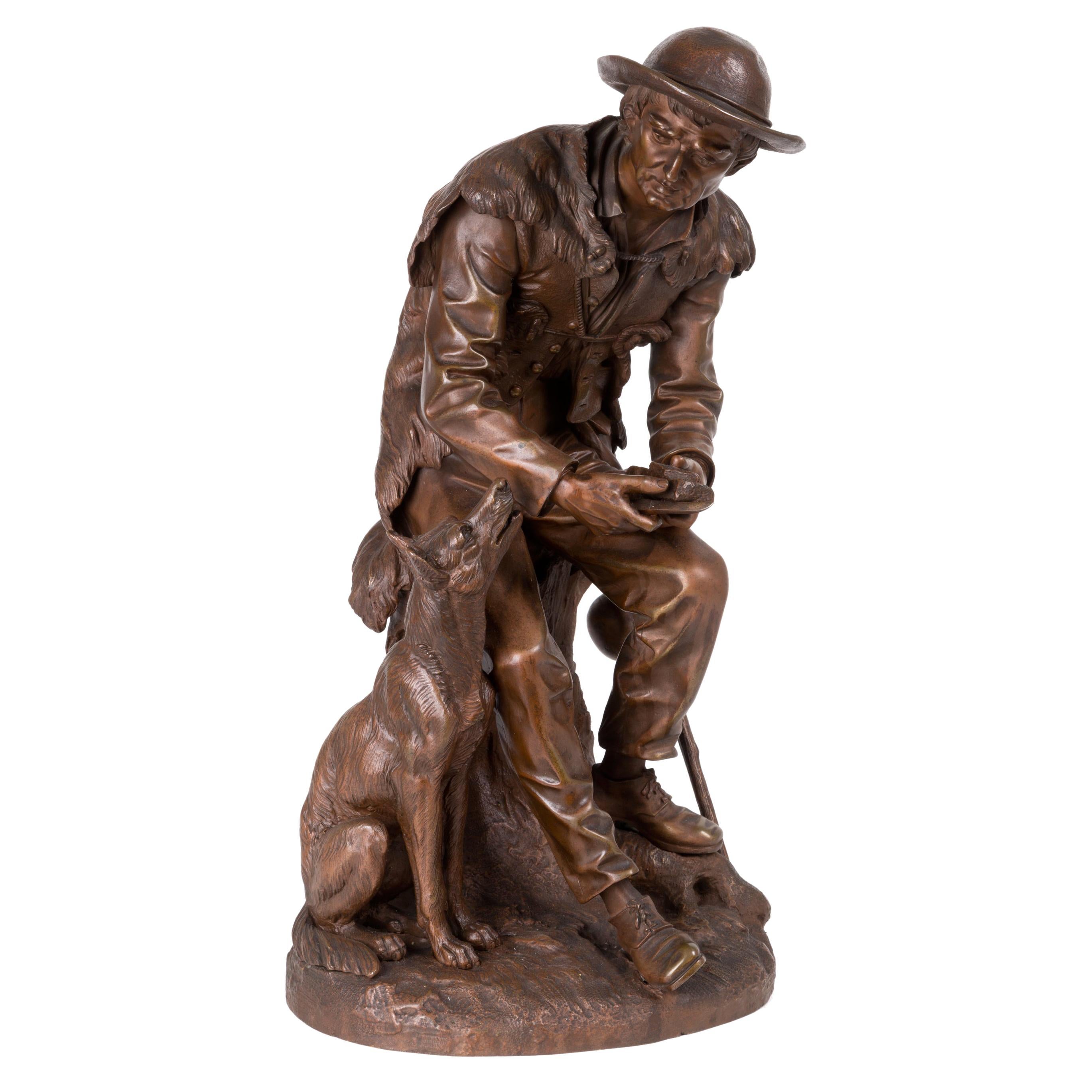 Sculpture en bronze d'Anatole J. Guillot représentant « un sculpteur sur bois assis avec un chien »