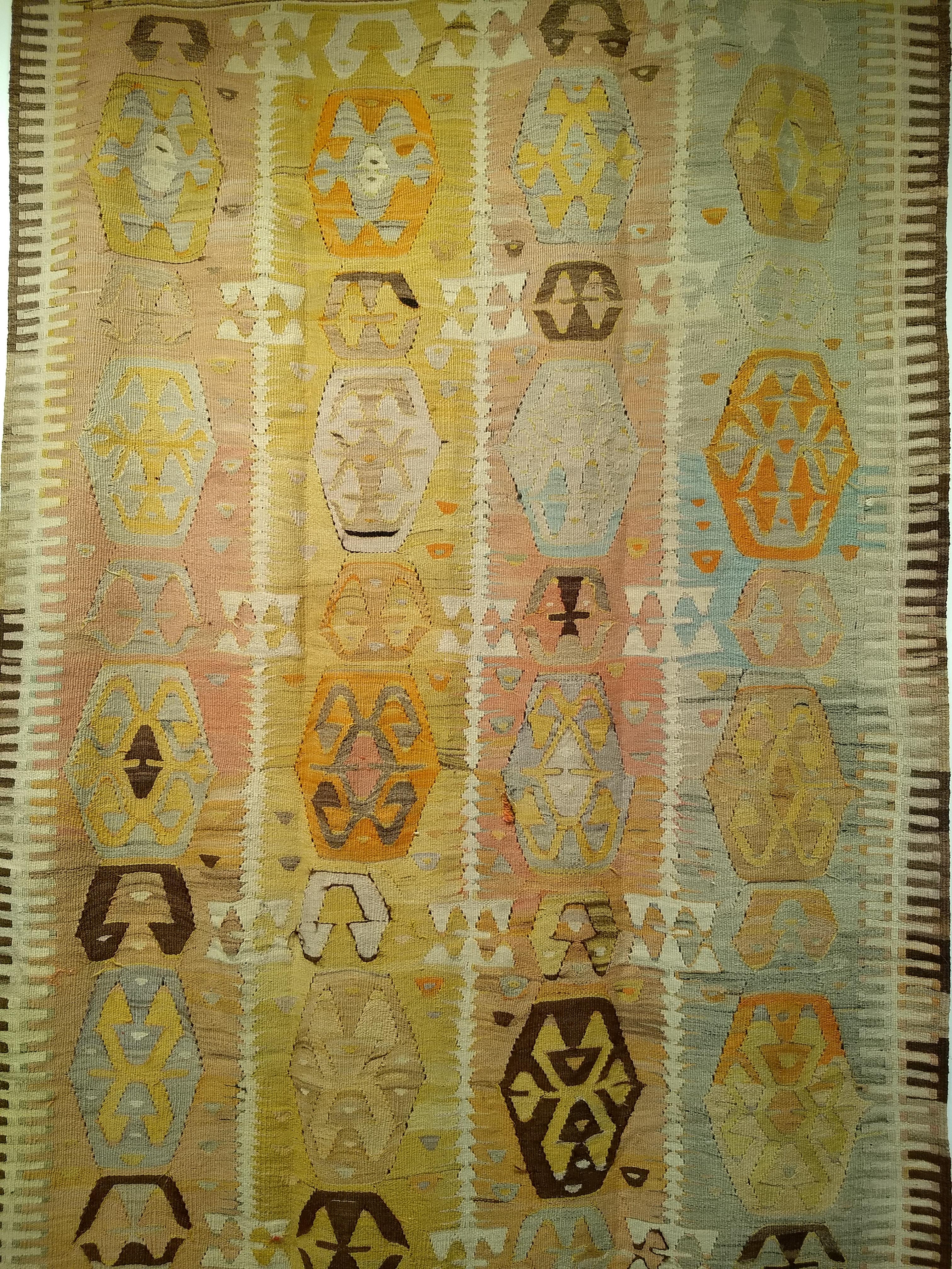 Vintage Anatolian kilim area rug in an allover pattern in aqua blue, pale yellow, pink from the early 1900s Turkey.  This Anatolian kilim has a very unique and desirable design and earth tone color palette.  The design contains four columns of