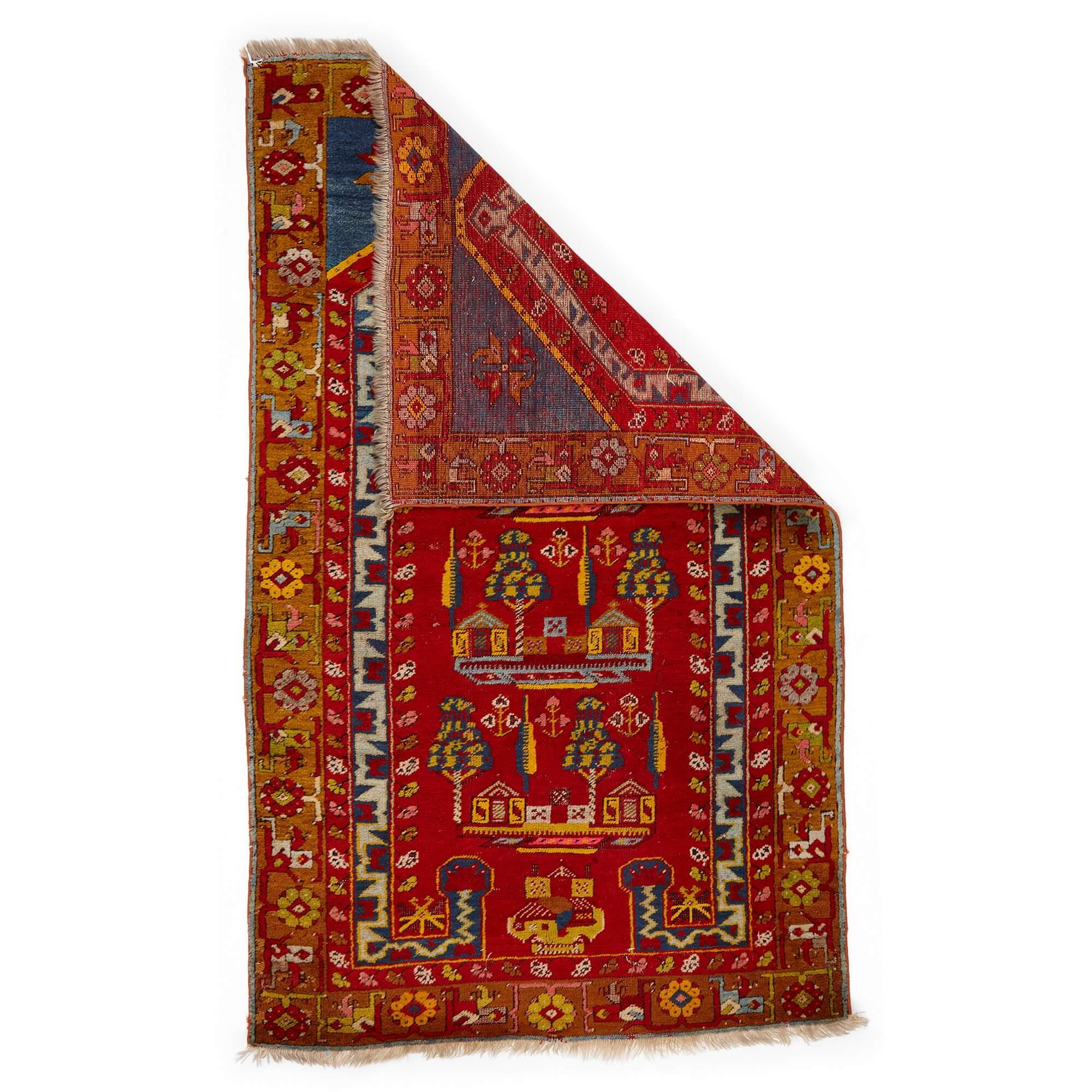 Anatolian Kirsehir prayer rug with a village design 
Turkish, 20th Century 
Height 155cm, width 96cm

This eye-catching pictorial prayer rug was skilfully woven from wool by Turkish carpet weavers in the 20th century. Its design is typical of rugs