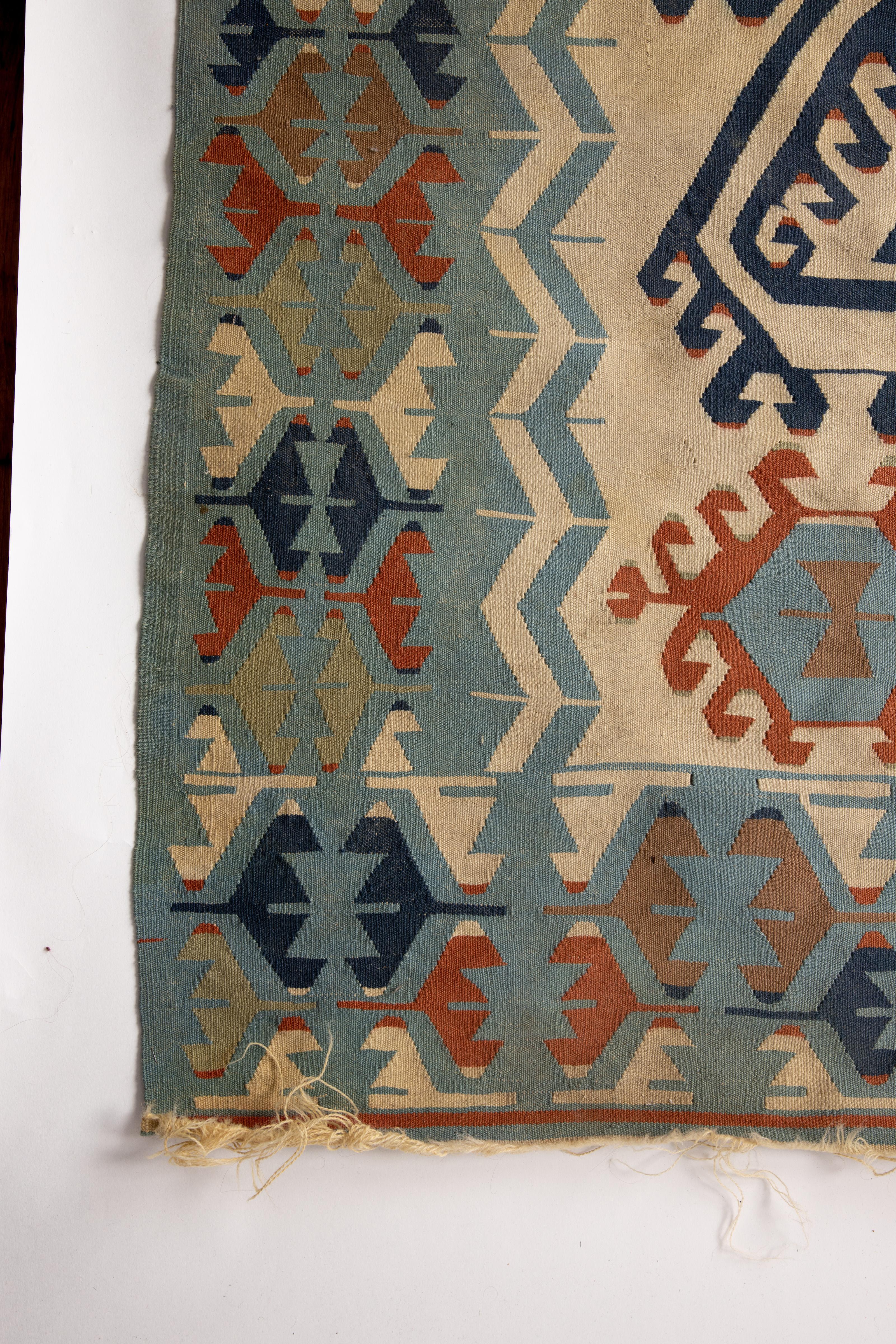 Ornate handwoven flat-weave kilim rug with natural pigment dyed wool. The designs woven in to the rug are all symbolic that have been passed done through generations of weavers for hundreds of years, if not more. Rich colors of indigo, coral, sky