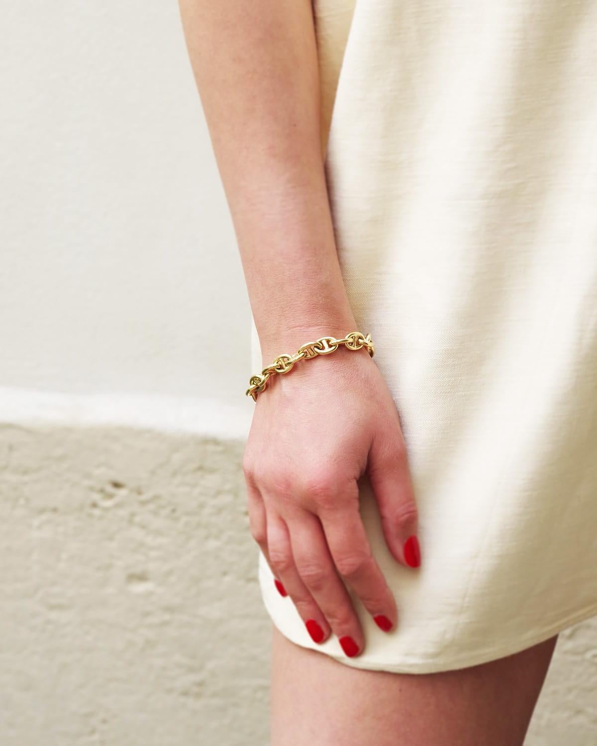 Bracciale con catena ad ancora in oro 18 carati, composto da una maglia marina cava o catena ad ancora che si chiude con una grande chiusura a moschettone. Formato da maglie ovali attraversate da una barra, che conferisce solidità al design di