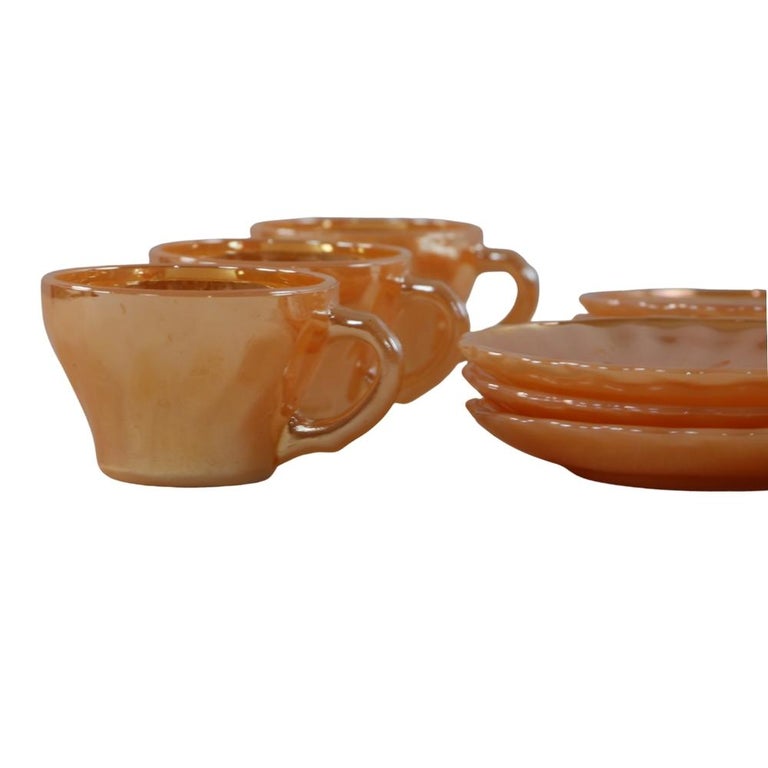 Fire King coffee set from Anchor Hocking from the 1960ths. Shining in a high-gloss peach-corall color, it looks different in every light. Set of 12 pieces. 6 cups and 6 placemats. This set of Fire King glass coffee was manufactured by Anchor Hocking