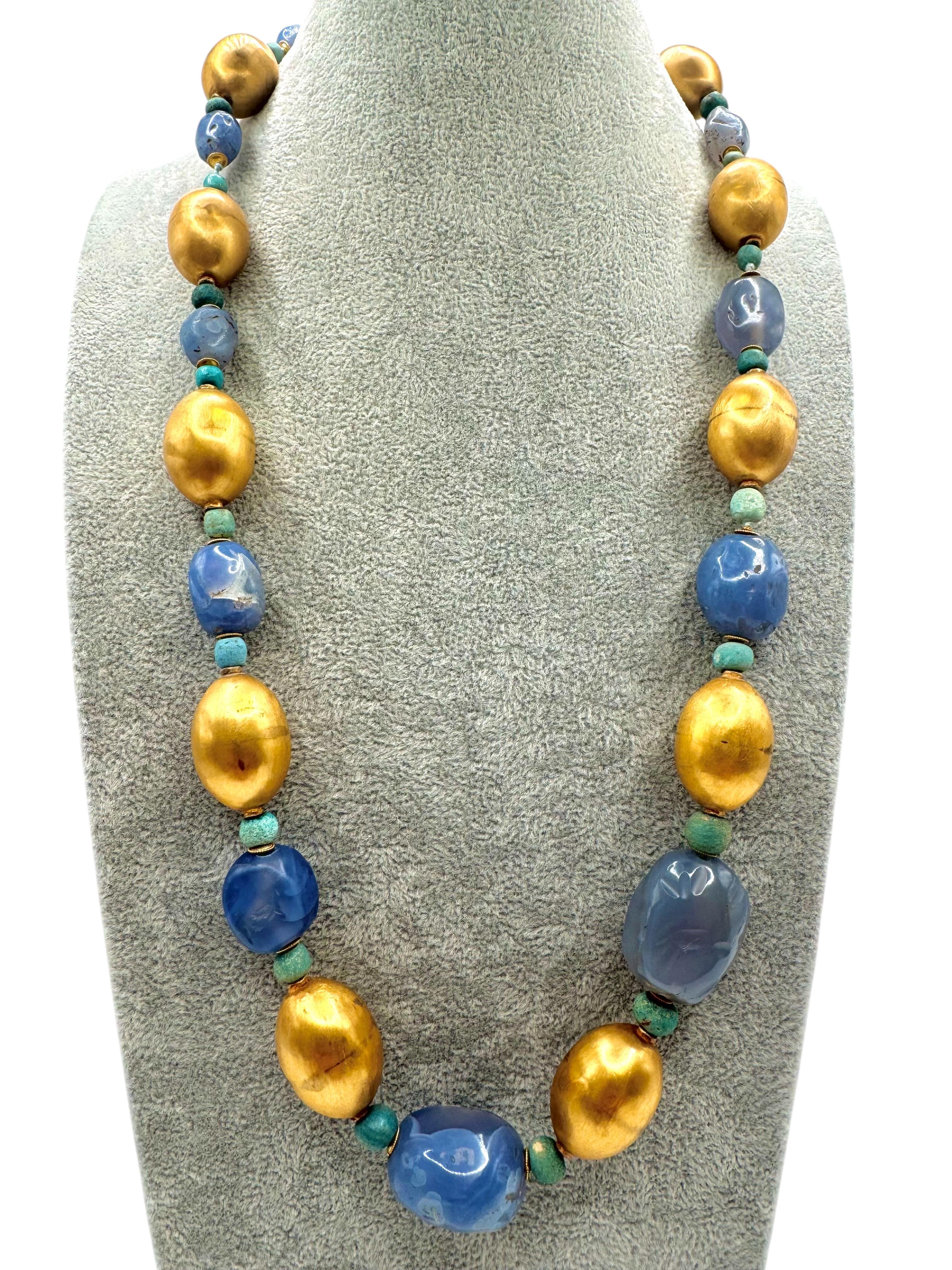 Questa rara collana risale all'Età del Ferro (X-VIII secolo a.C.) e presenta antiche perle di calcedonio blu intagliate a mano della regione di Amlash. Le pietre organiche e libere sono splendidamente intervallate da perline in oro giallo 14k e