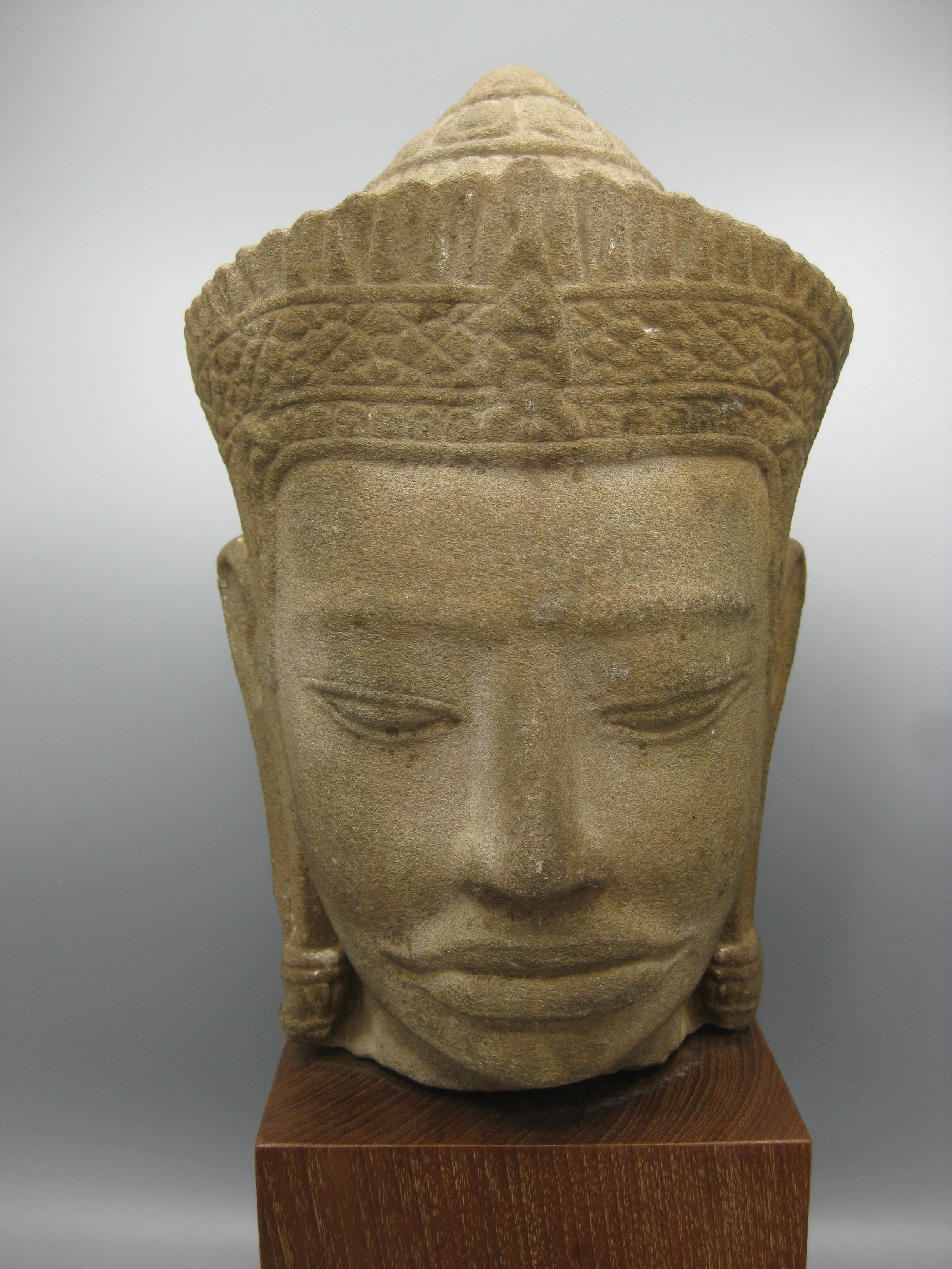 Remarquable statue/sculpture de tête de Bouddha Vishnu en grès sculpté, datant du 12e siècle, de l'époque khmère/cambodgienne. Monté sur une base en bois de teck. Marqué sur le fond par le propriétaire d'origine, il a été acheté en 1960. Les États
