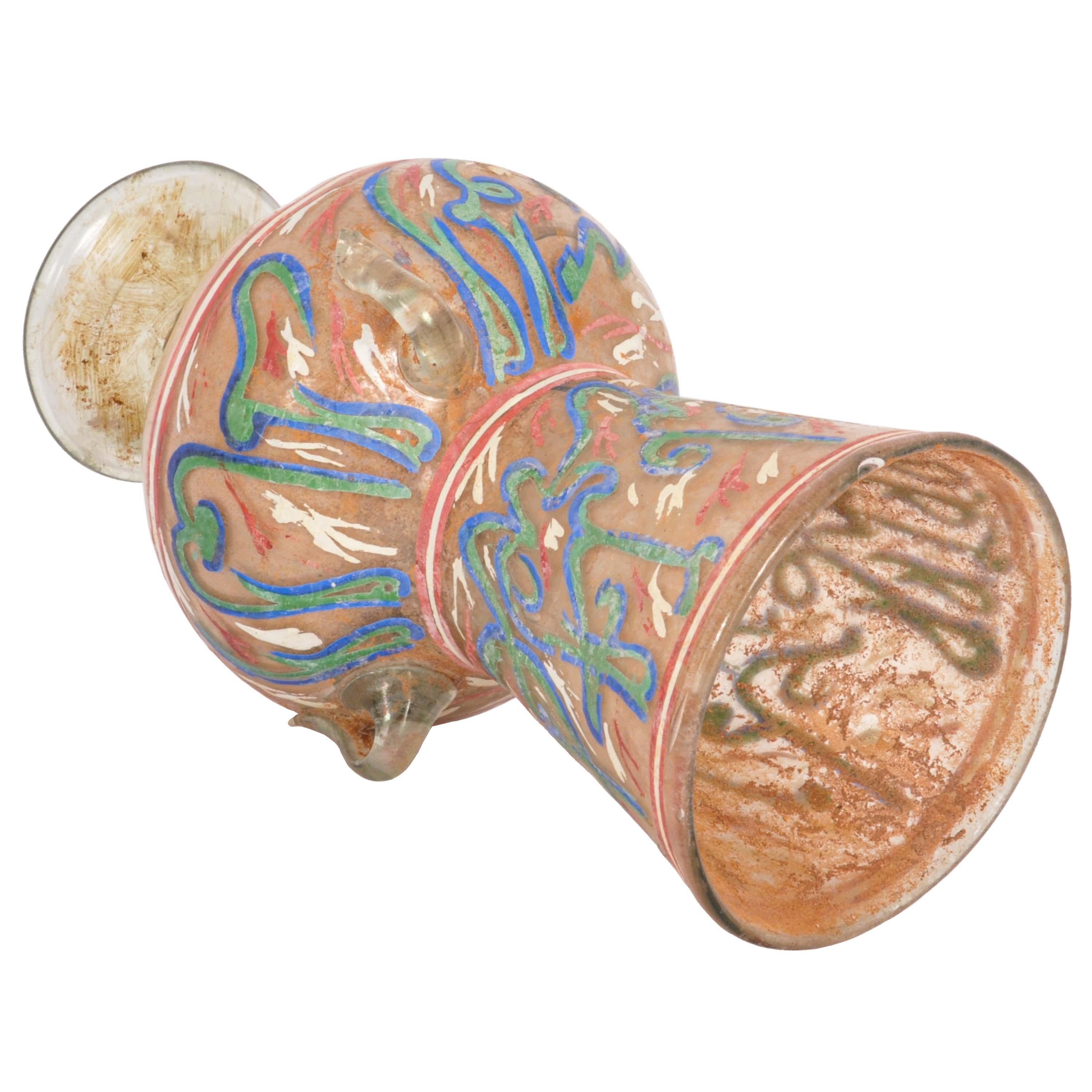 A rare and ancient Mamluk period Islamic handblown glass mosque lamp, Egypt or Syria, early 1500's.
The lamp of diminutive form & having a flared neck with Islamic calligraphy, the globular body also decorated with quranic script in blue. There are
