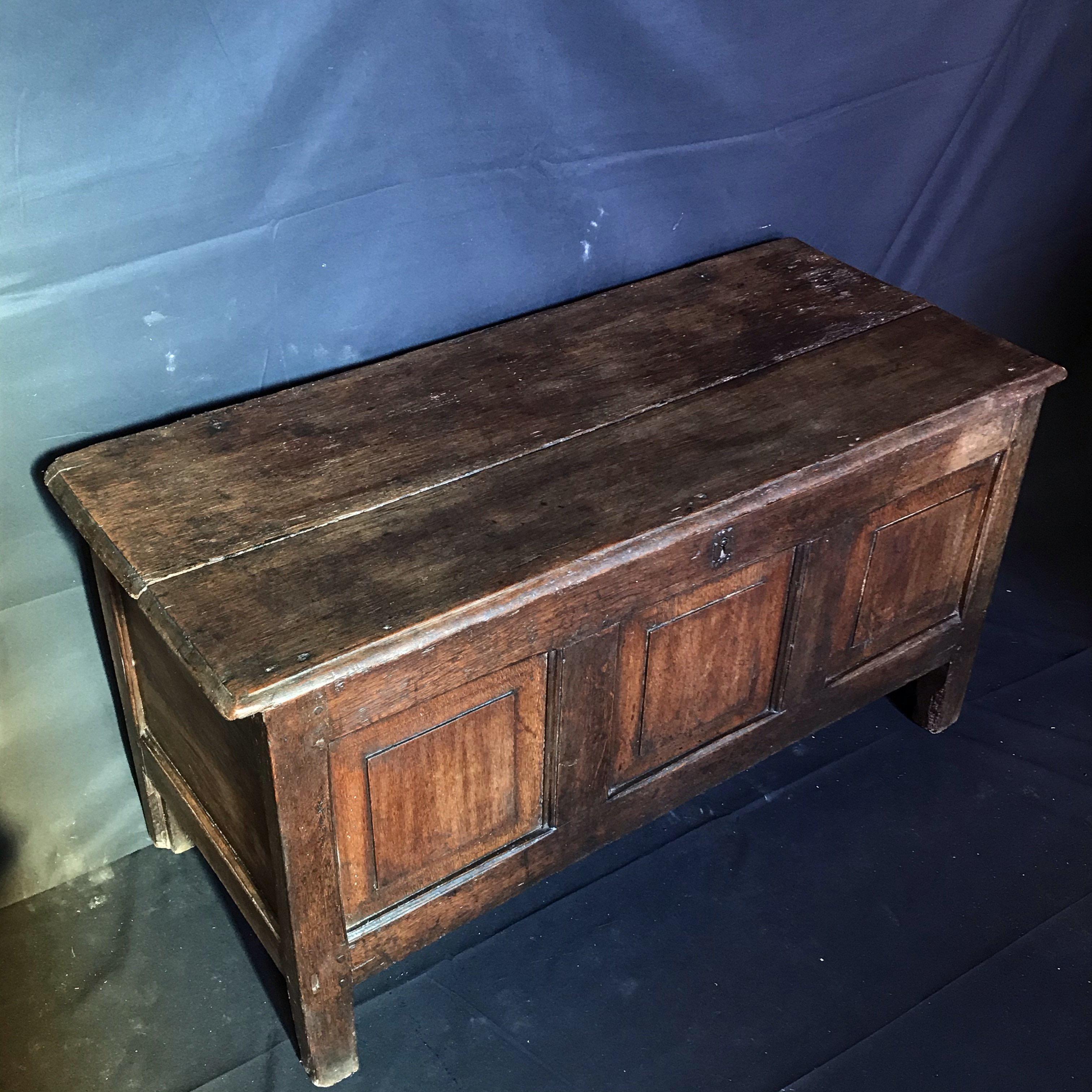 A simple and gorgeous very old late 17th century panelled oak coffer having three panels to the front, one panel to each side, and raised on stile feet. Original steel lock plate. Lovely color and patina!
#4494.