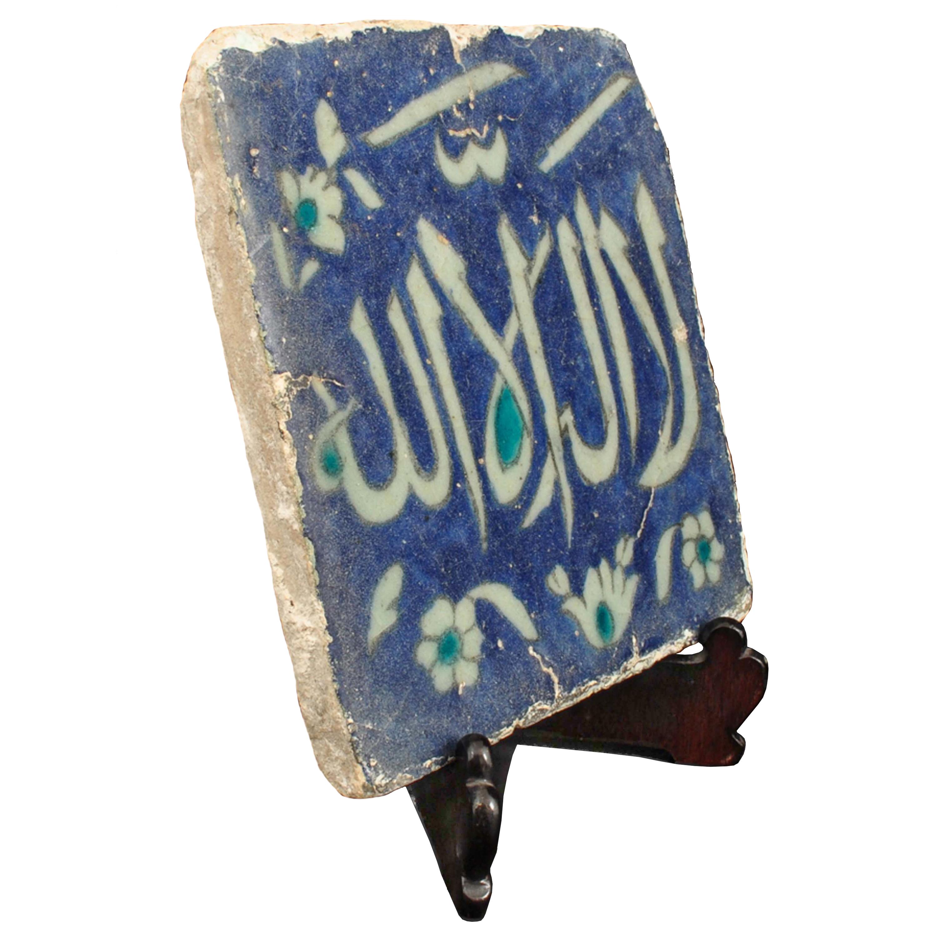 An important antique 16th century Ottoman calligraphic Iznik pottery tile, Turkey, circa 1580. 
The tile of rectangular form, painted in underglaze cobalt blue, outlined in black and decorated with a large white thuluth inscription reserved against
