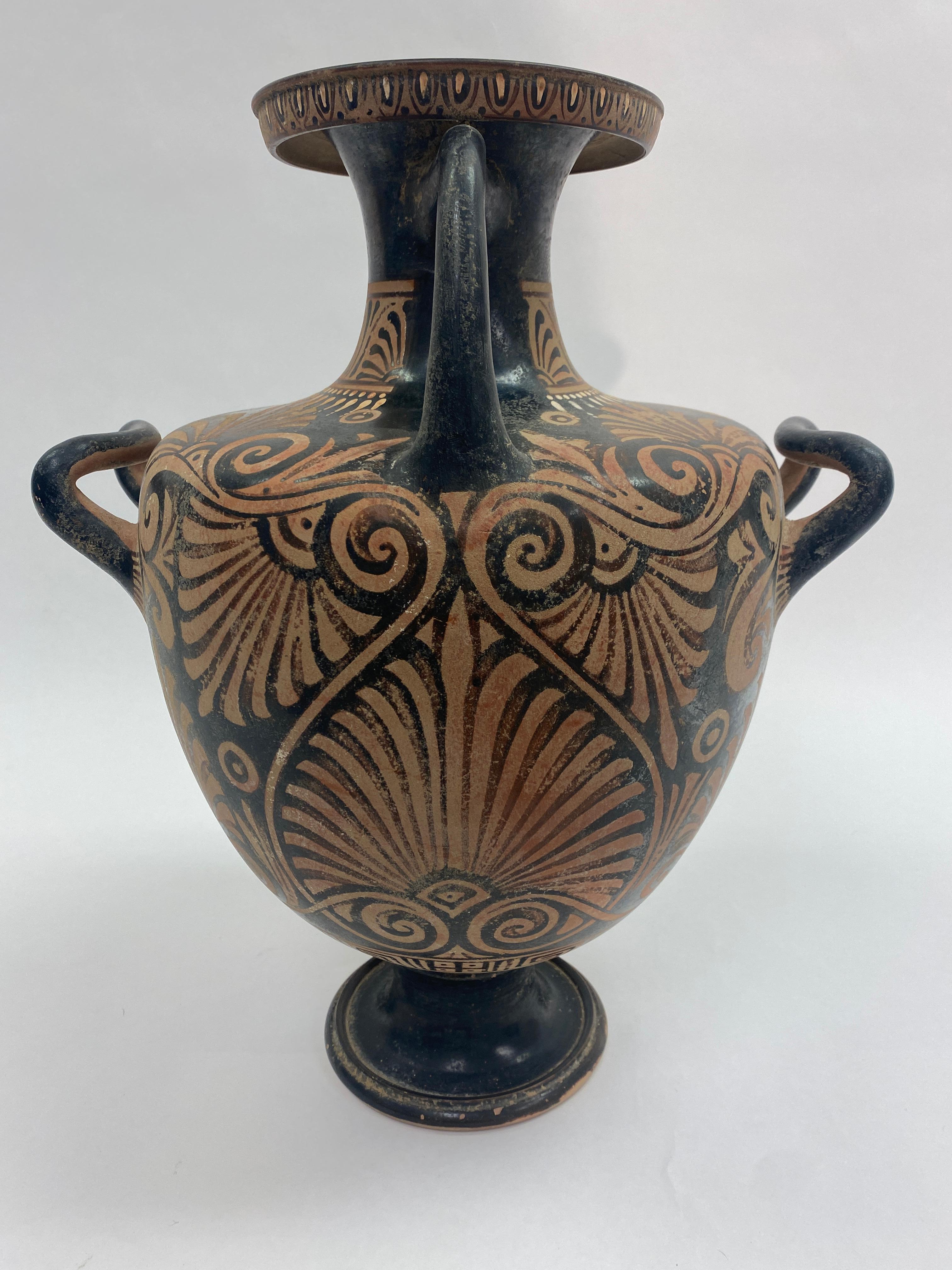 Grand Tour Red-Figure Greek hydria terra-cotta pottery. Item rests on a flared pedestal foot rising into a bulbous shaped body resolving into a narrow flared lip. Two side handles for lifting and one on the rear for pouring of water. 