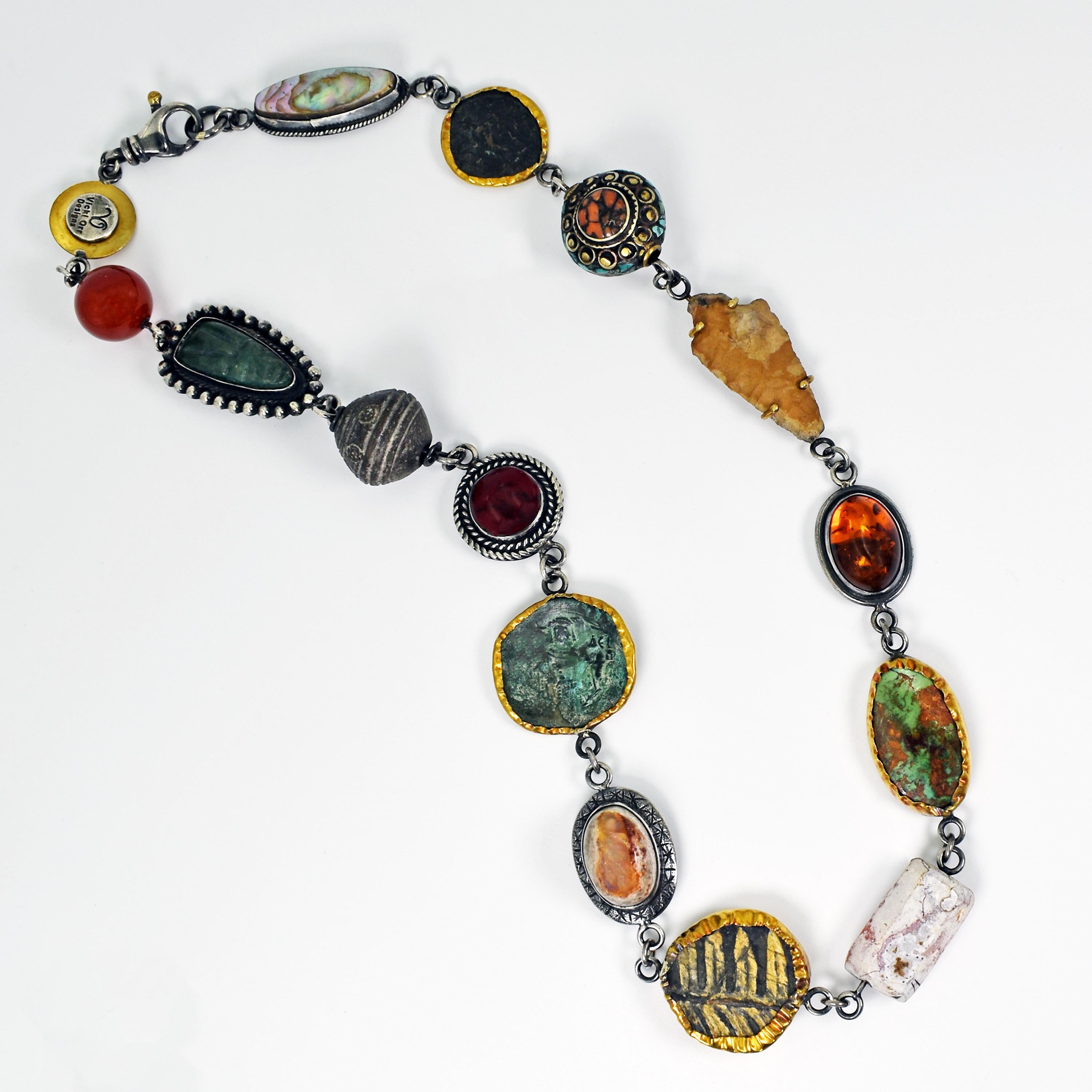 Unique statement necklace featuring a variety of ancient artifacts and gemstones including Mother-of-Pearl, ancient Roman coin, antique Turquoise & Coral Tibetan bead, arrowhead, Amber, King Manassa Turquoise, ancient Agate bead, plant fossil,