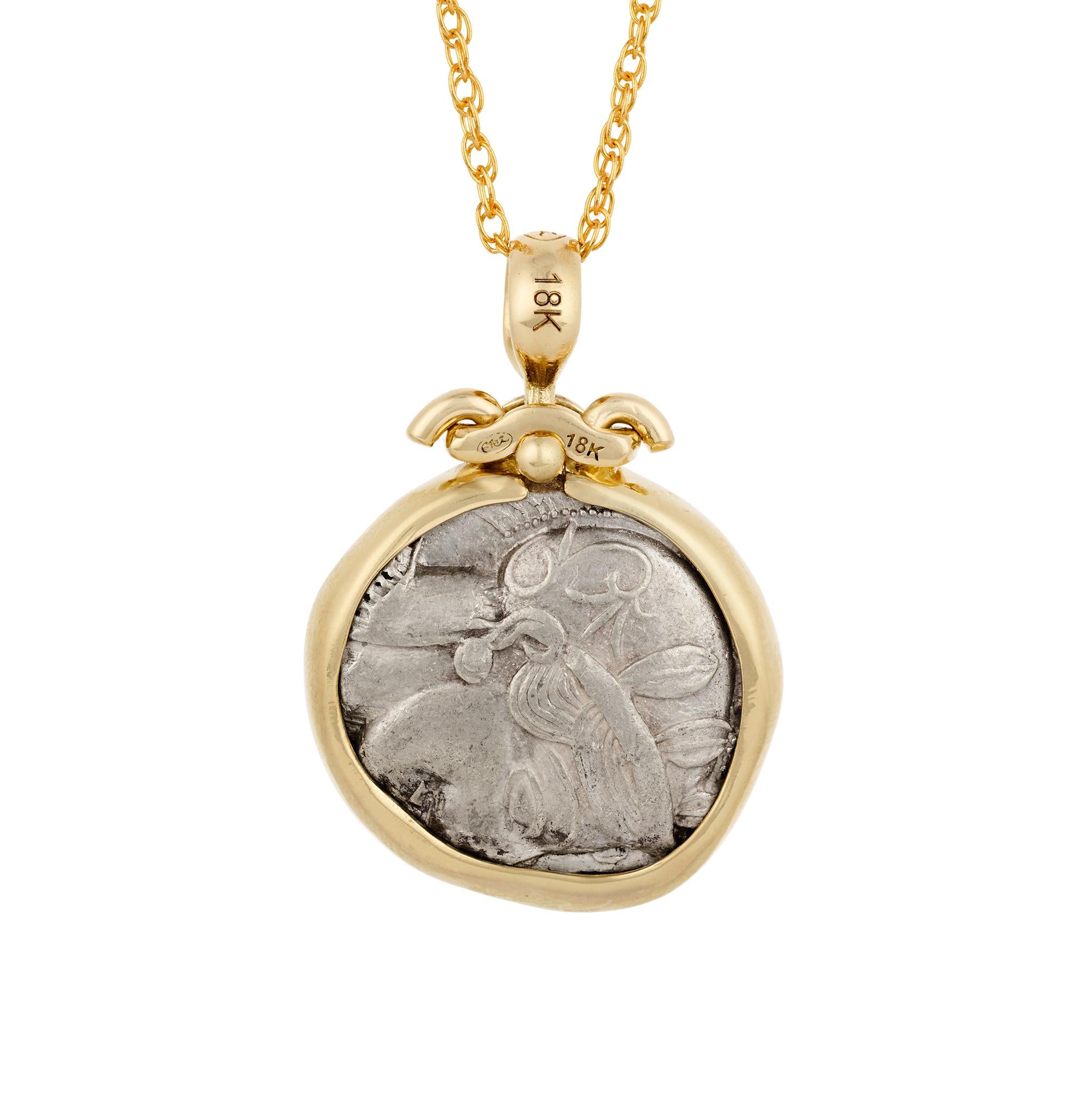 Celebrating the Golden Age of Athens, this pendant is formed from an authentic Athenian silver tetradrachm dating from 454–405 BCE. The obverse depicts Athena wearing her crested Attic helmet adorned with olive leaves, while the reverse shows her