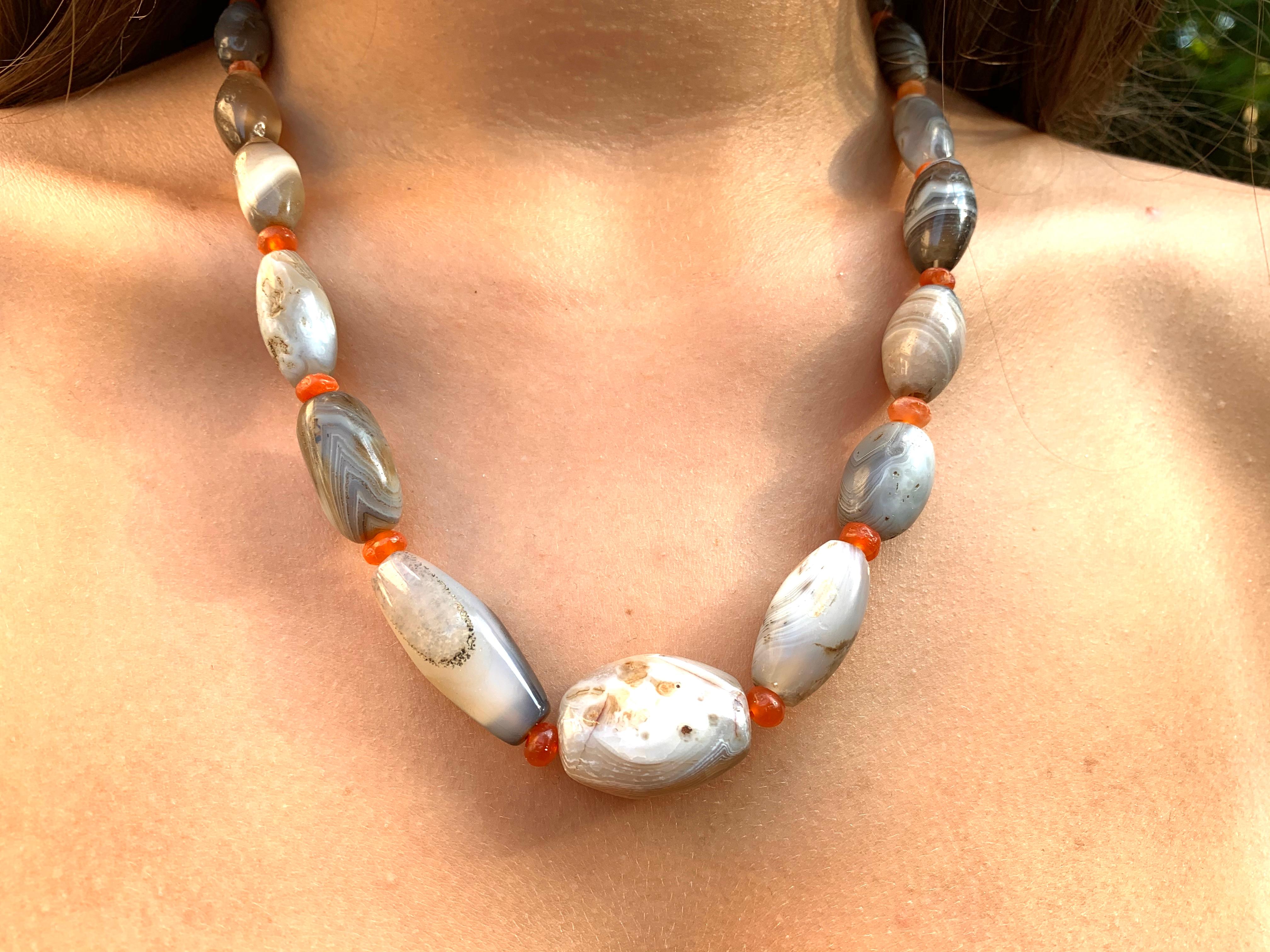 Ancient amulet necklace composed of twenty one well matched graduated banded agate biconical beads measuring 32mm to 17mm and 22 carnelian beads approximately 5mm in diameter. The agates of exceptional figure showing 