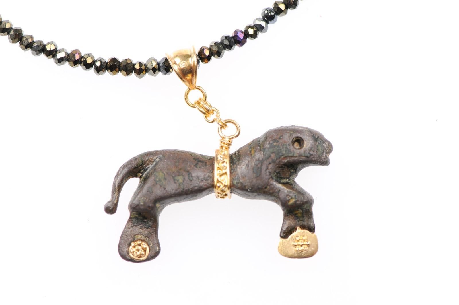 An ancient bronze Roman lion artifact (circa 1st-2nd century AD) which has been set in a custom 21-karat gold hanging pendant and Bail. The animal has been adorn with 21-karat gold accents on the feet. Pendant and Bail measures approximately 1.5