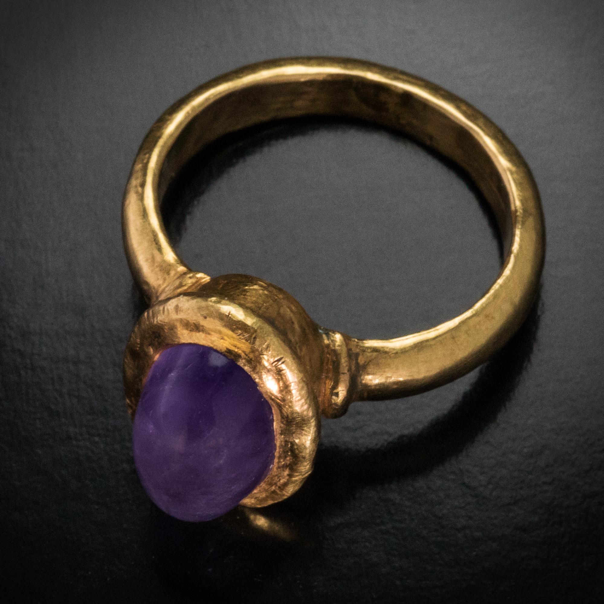 Byzantine empire, circa 6th century AD.
The hollow gold ring is embellished with an oval cabochon cut amethyst.
The amethyst measures 12.38 x 7.55 mm. Size of the bezel is 15 x 11 mm (5/8 x 7/16 in.)
Height of the setting and amethyst is 10 mm (3/8