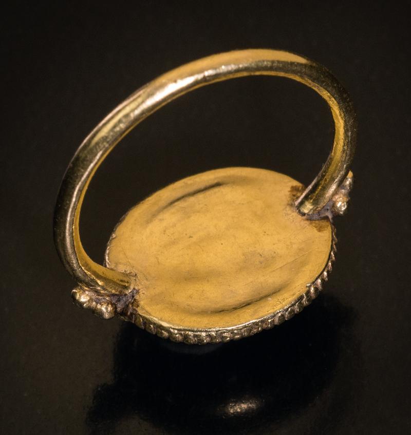 This early Byzantine ring, circa 5th-6th centuries CE, is finely crafted in 21 Karat gold. The ring features an oval cabochon cut garnet of a deep red color set in a ribbed bezel and flanked at the shoulders by gold beads.

The bezel measures 16 x