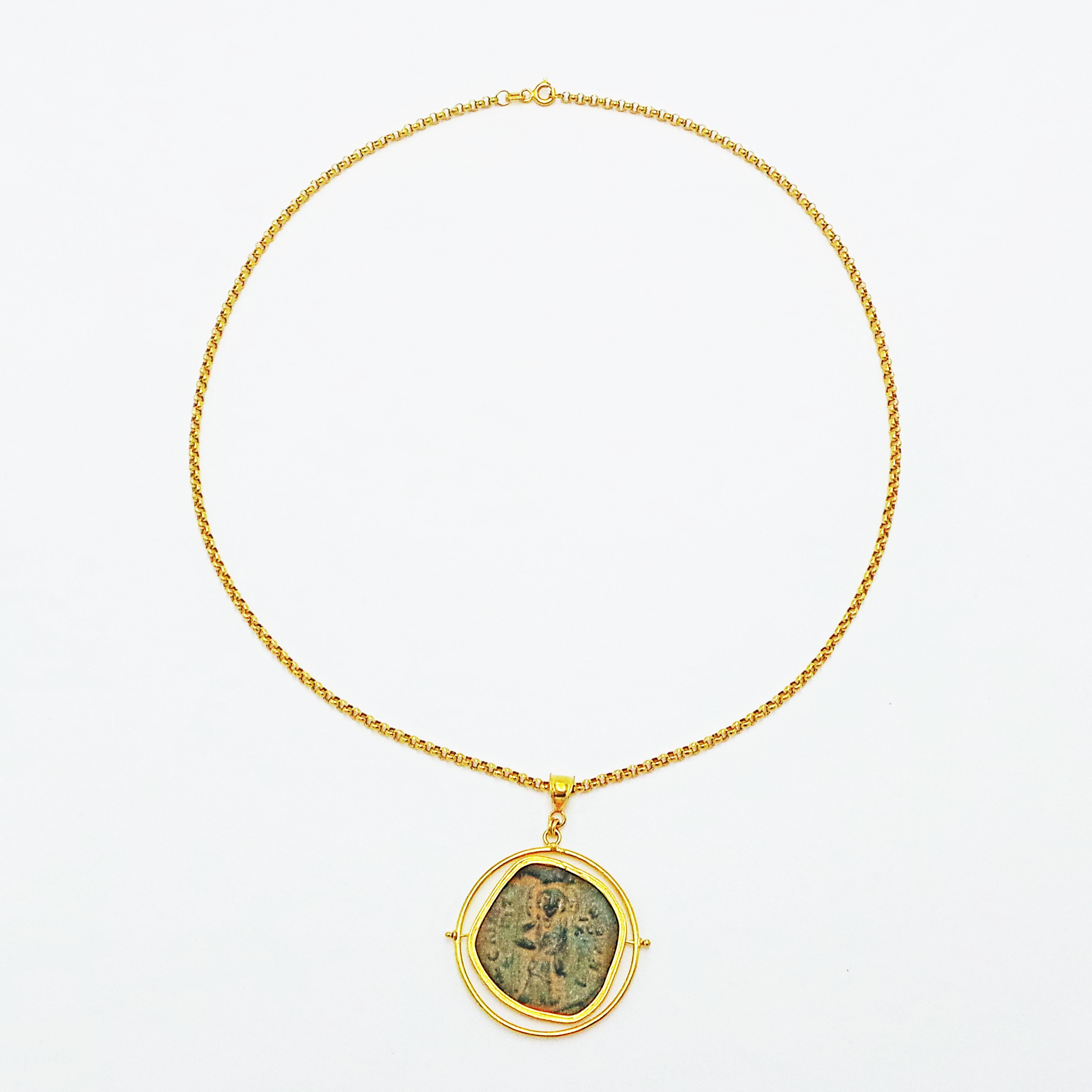 Entrambe le facce di questa antica moneta bizantina (Kōnstantinos X, Follis, zecca di Constantinopolis, 1059-1067 d.C.) possono essere messe in mostra in questo ciondolo girevole/reversibile in oro giallo 22k. Il ciondolo a forma di moneta si trova