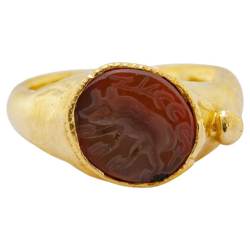 Featuring one carved carnelian intaglio, 12.5 X 11.0 mm, depicting a Boar, and the word/name
Zuccci, flush set in a hand forged, 22k yellow gold mounting, 12 mm to 3.3 mm, size: 8.5, Gross
Weight: 6.45 grams.