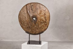 Rueda de carro antiguo montada sobre base de laca negra con carácter rústico