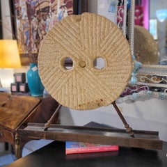 Antigua piedra de molino castellana de granito y pie de escultura de hierro