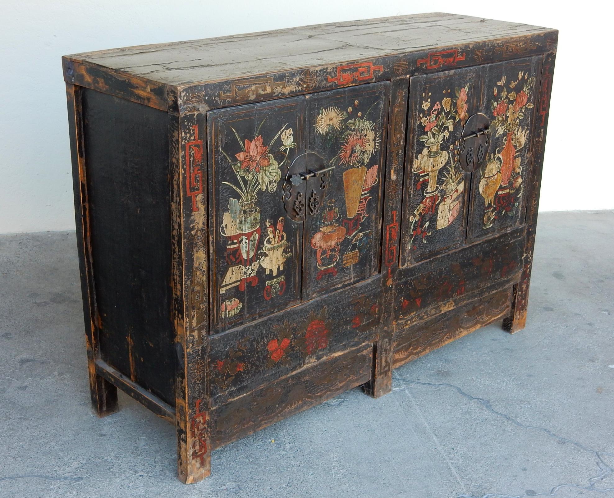 19th century Chinese apothecary lacquered cabinet.
Warm hand painted floral scenes on door fronts with 
large bronze medallion pulls.
Double doors on each side opening to deep storage with center shelves.
Completely original with no repairs. 
A
