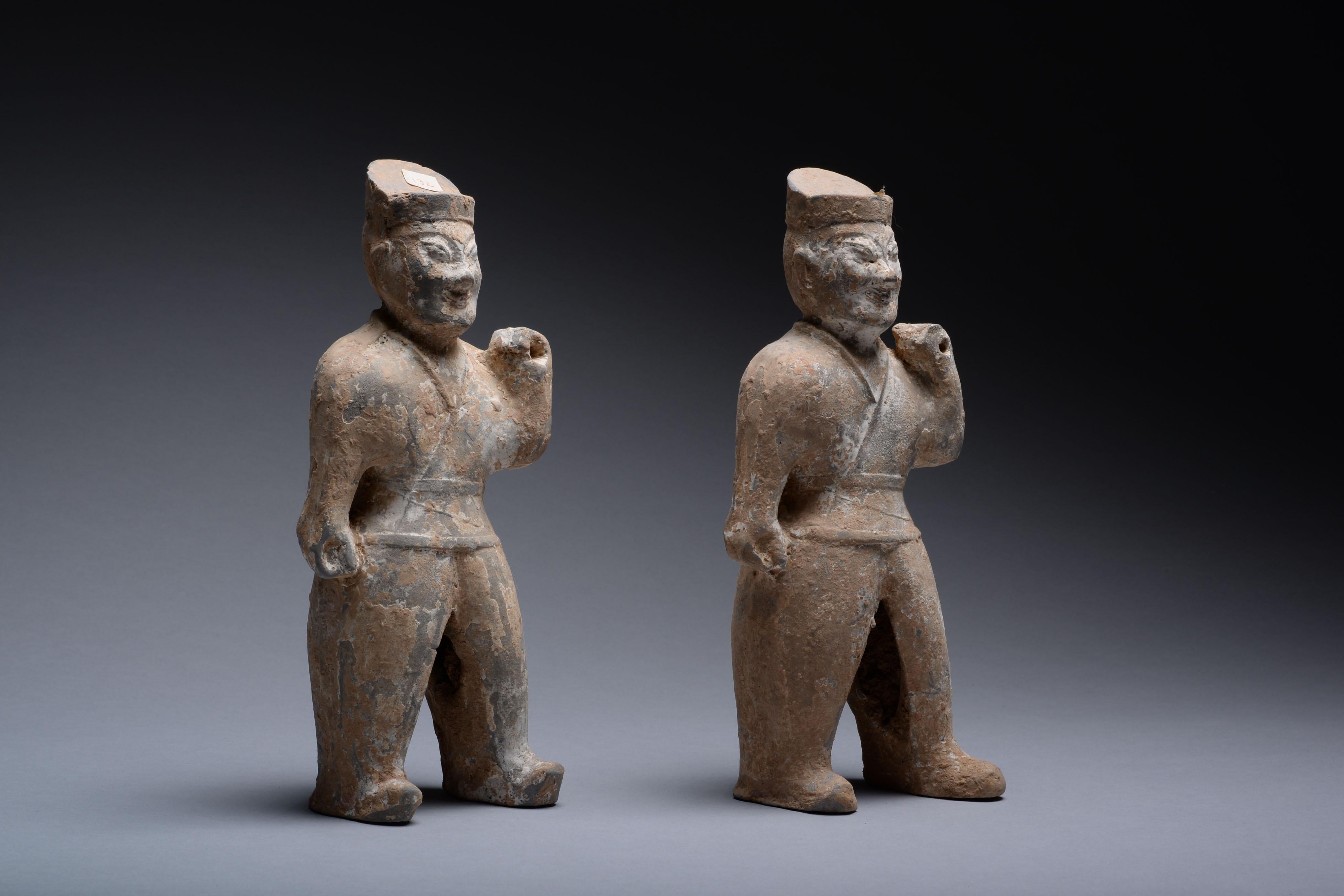 A pair of ancient Chinese terracotta warriors, dating to the Western Jin dynasty, 265-316 AD.

The figures stand defiantly, their right arms by their sides, their left raised and pierced, likely to hold a wooden spear in antiquity. Both figures