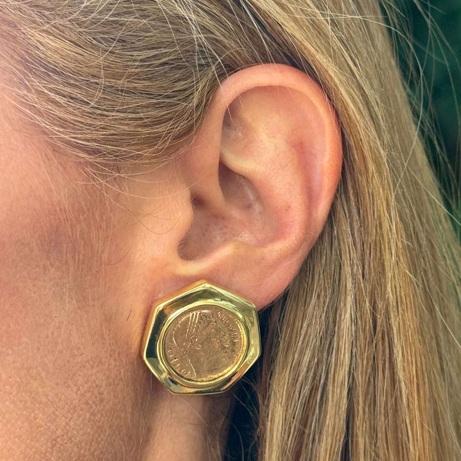 Coin vintage earrings crafted in 18 karat yellow gold (14 karat yellow gold cufflink findings). The earrings feature copper coins encased in a heptagon shape with leverback posts. The earrings measure 1.00 x 1.00 inch.