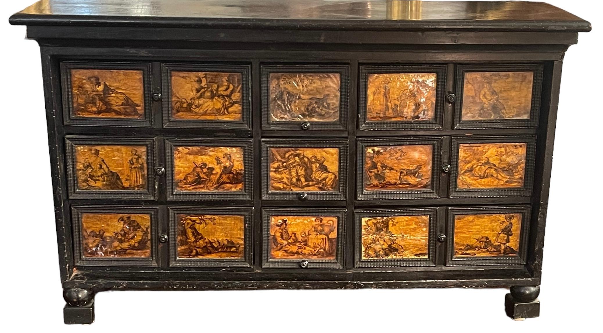 Antiker Münzschrank (Kabinett), 1600er Jahre, neapolitanisch.

Wertvolles und seltenes Möbelstück mit einer Struktur aus Ebenholz, 9 Schubladen und 15 Kacheln auf einer Silberplatte, einer Schellackschicht und Tuschezeichnungen, die Szenen aus dem