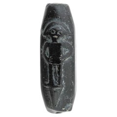 Ancien sceau cylindrique sculpté dans une pierre noire