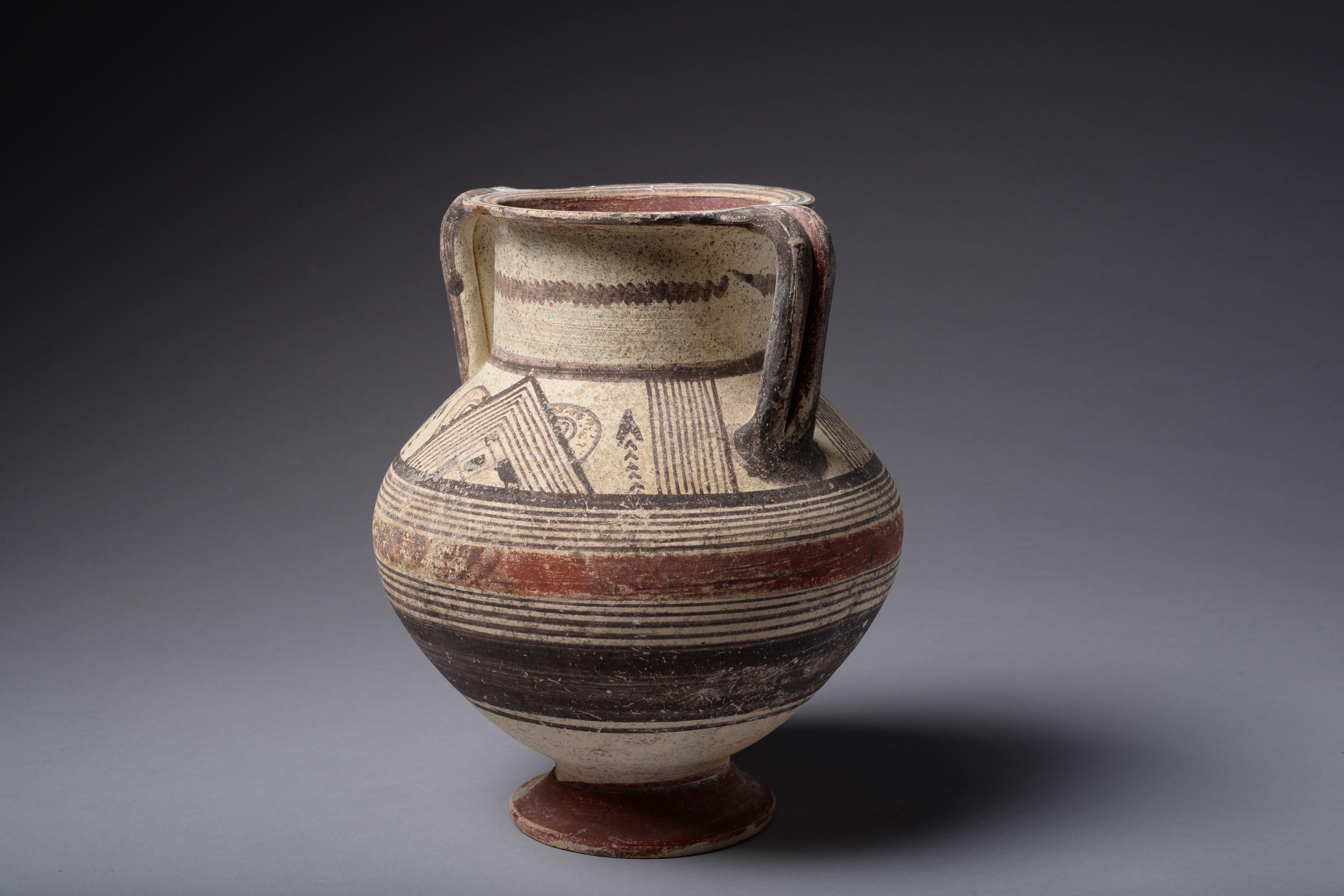 A well-preserved and richly decorated polychrome amphora, with arrows, checks, and bands of red and black paint. The herringbone decorations on the neck of the vessel probably represent abstract fish. This motif is more commonly found on the