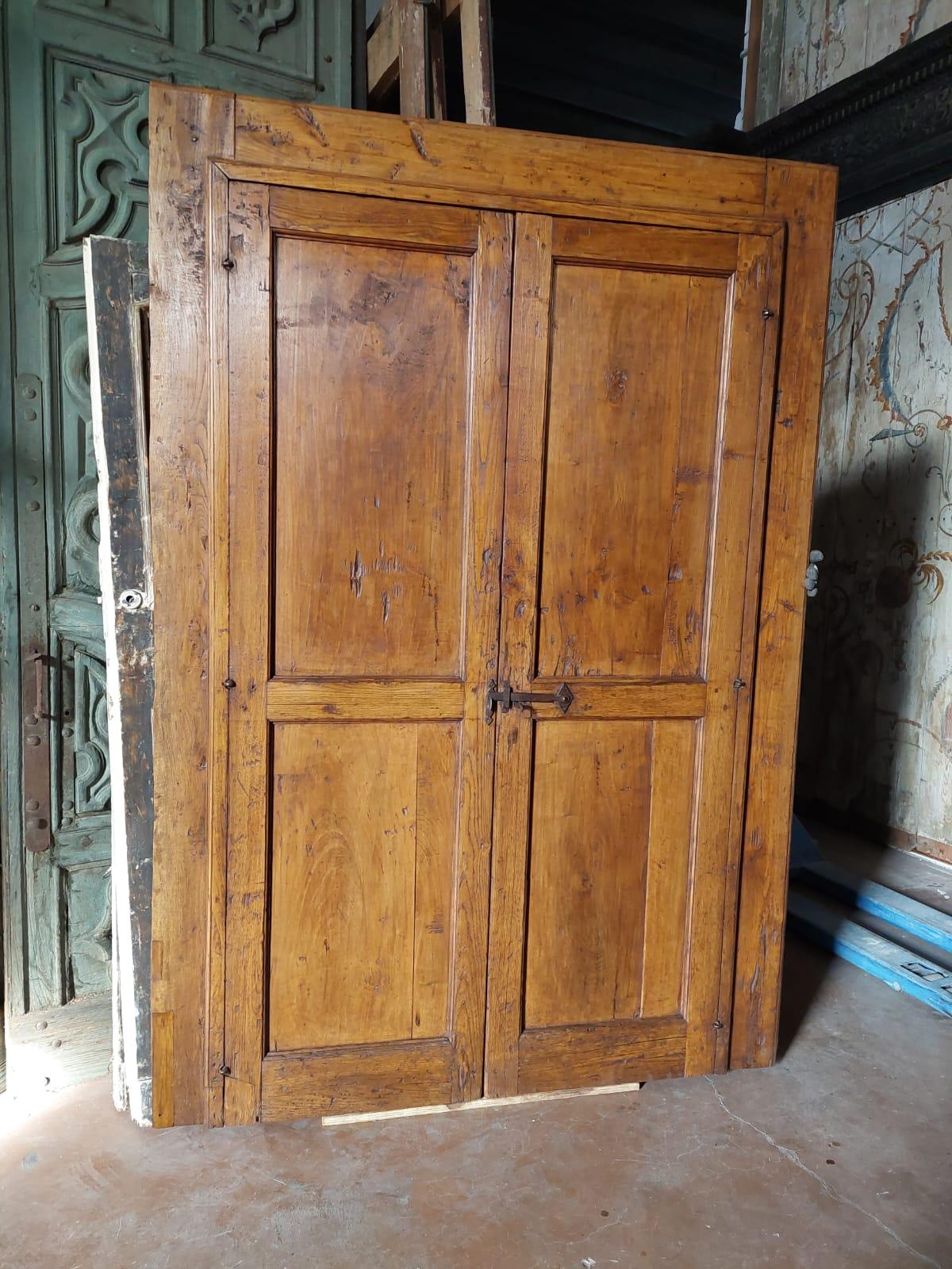 Ancient door/cabinet with two doors in classic rustic style, handmade with larch wood and poplar wood panels, coming from the mountains of northern Italy, 18th century. Door with a very fascinating shade of colour, usable both as a door and as a